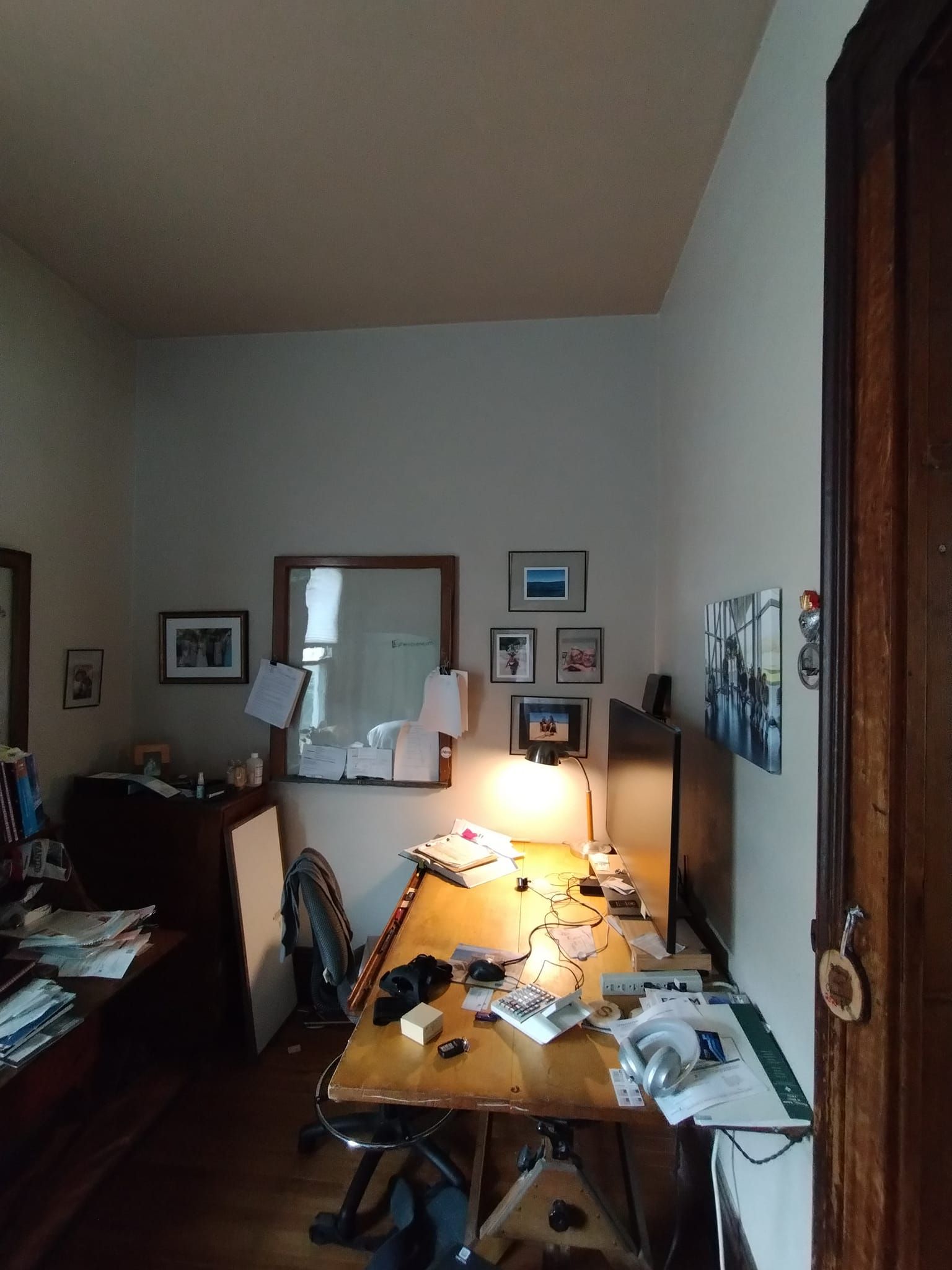 A room with a desk and a mirror on the wall