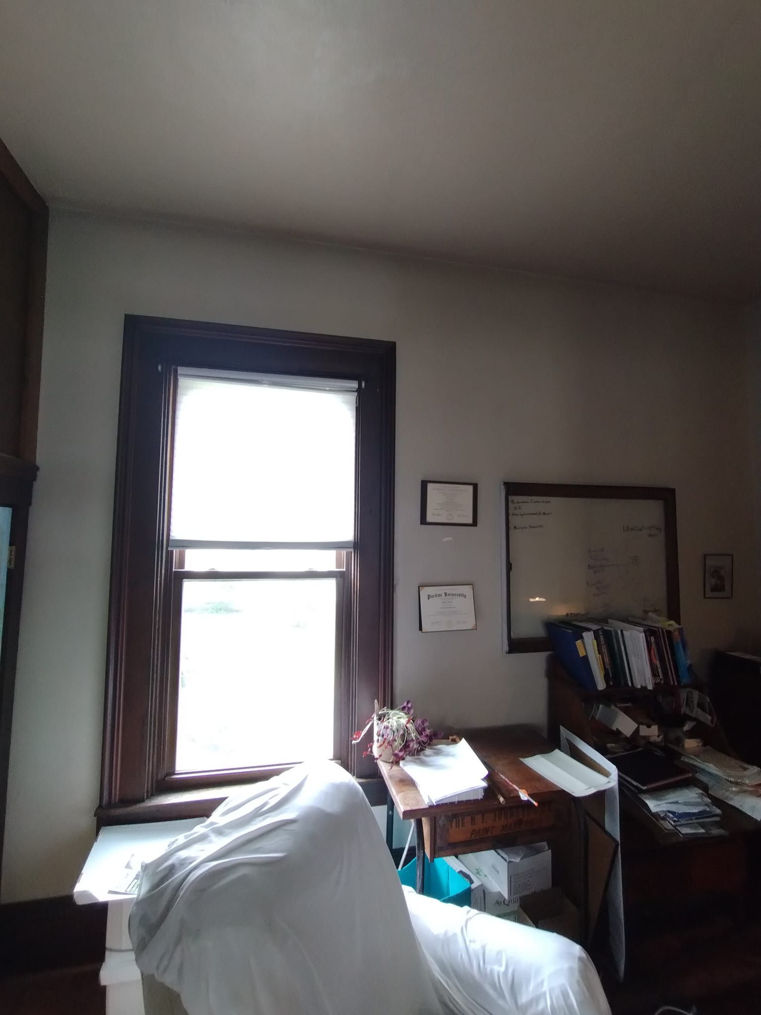 A room with a chair a desk and a window