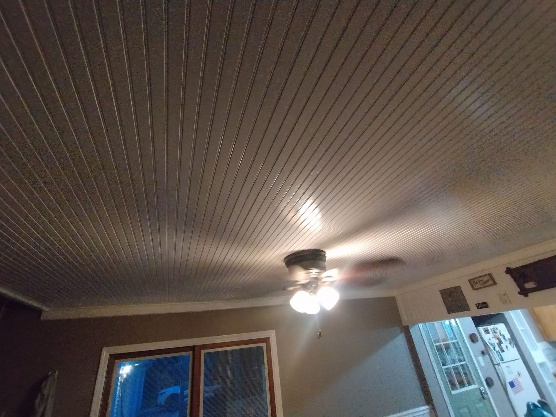 A ceiling fan is hanging from the ceiling of a room.