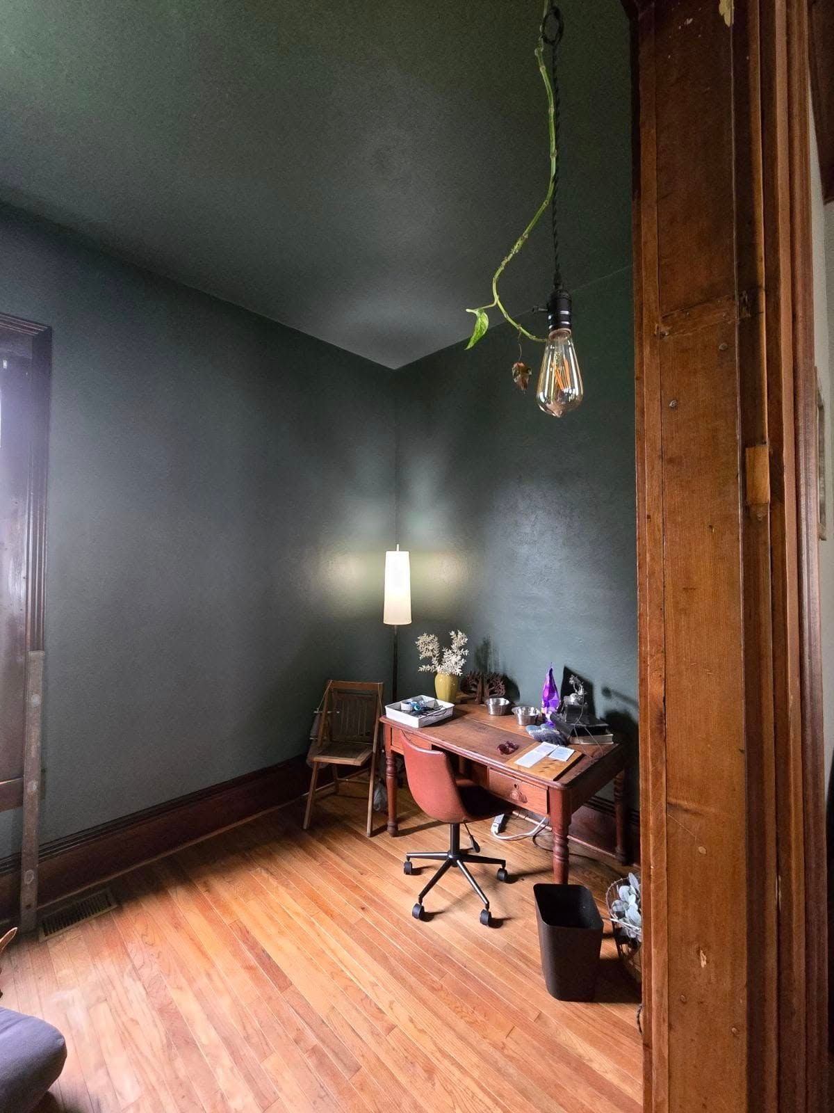 A room with a desk and chair in it.