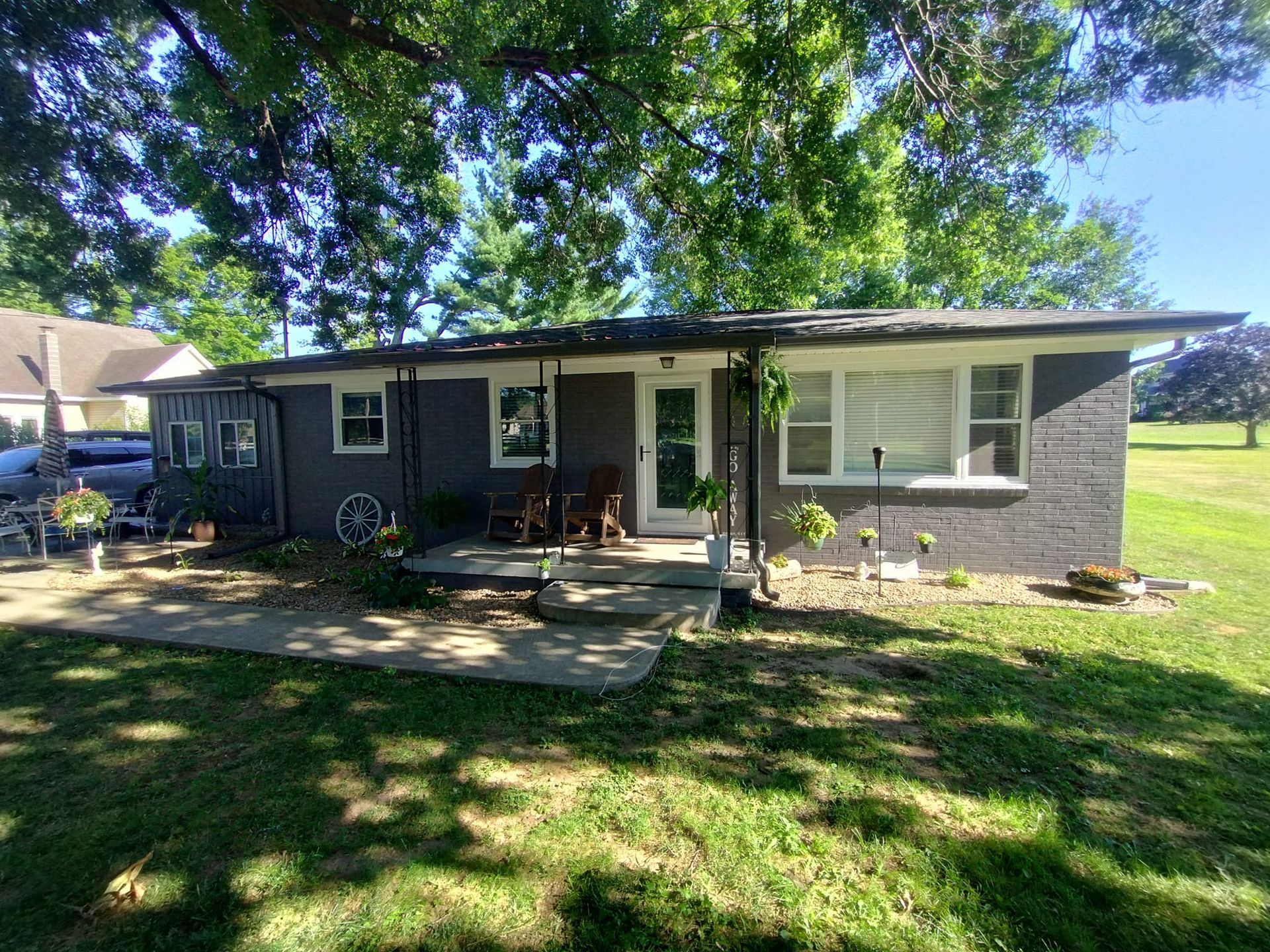 A small house is sitting on top of a lush green field.