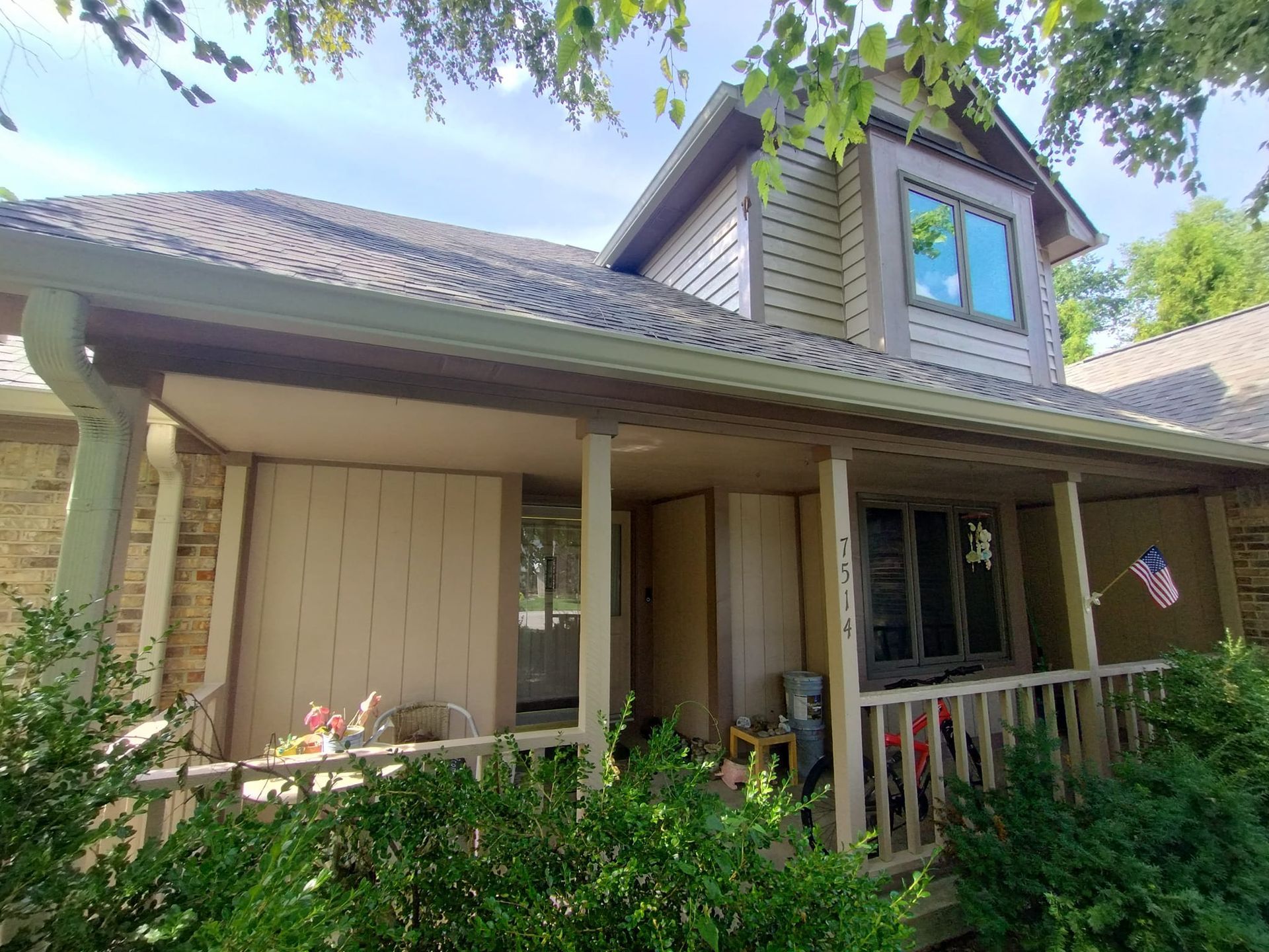 A house with a porch and a flag on it.