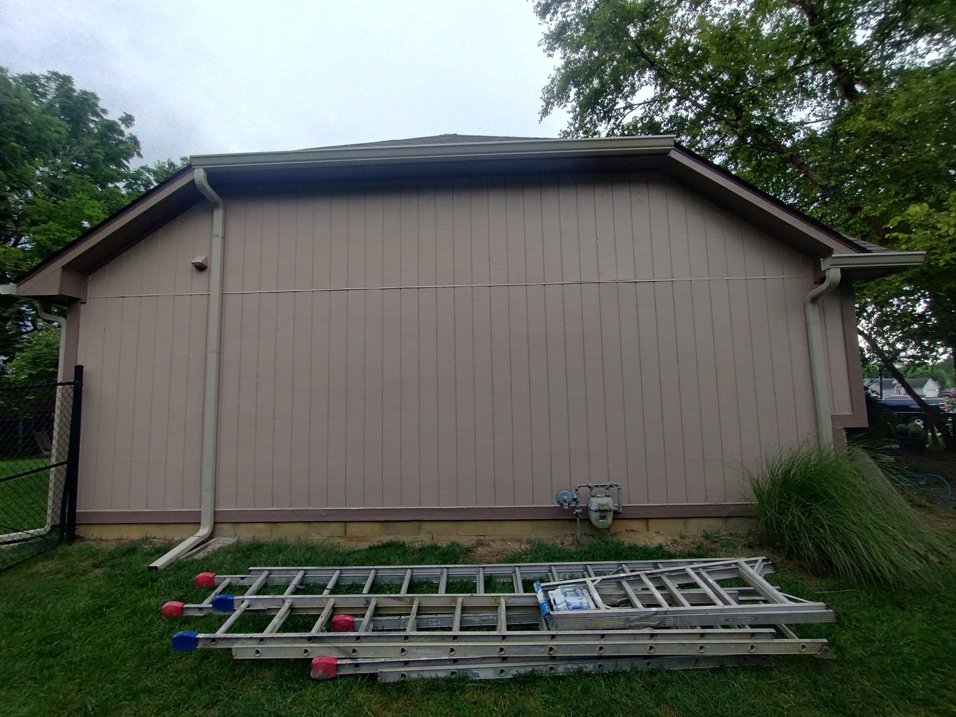 A ladder is sitting in front of a garage door.