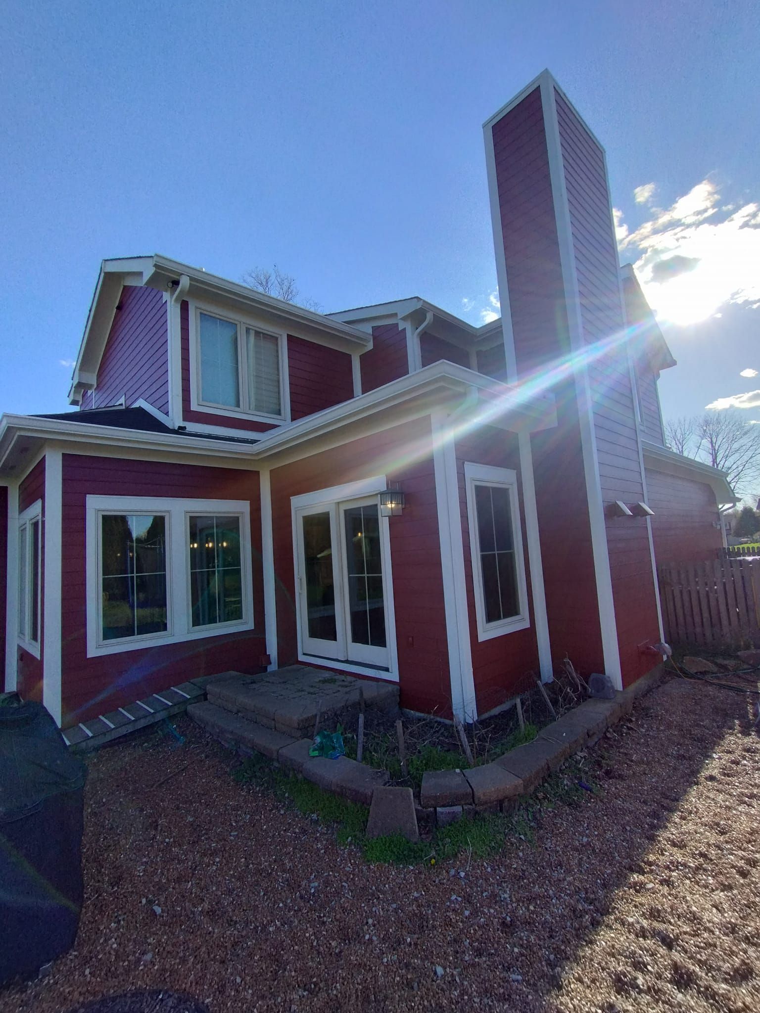 A red and white house with a chimney on the side of it.