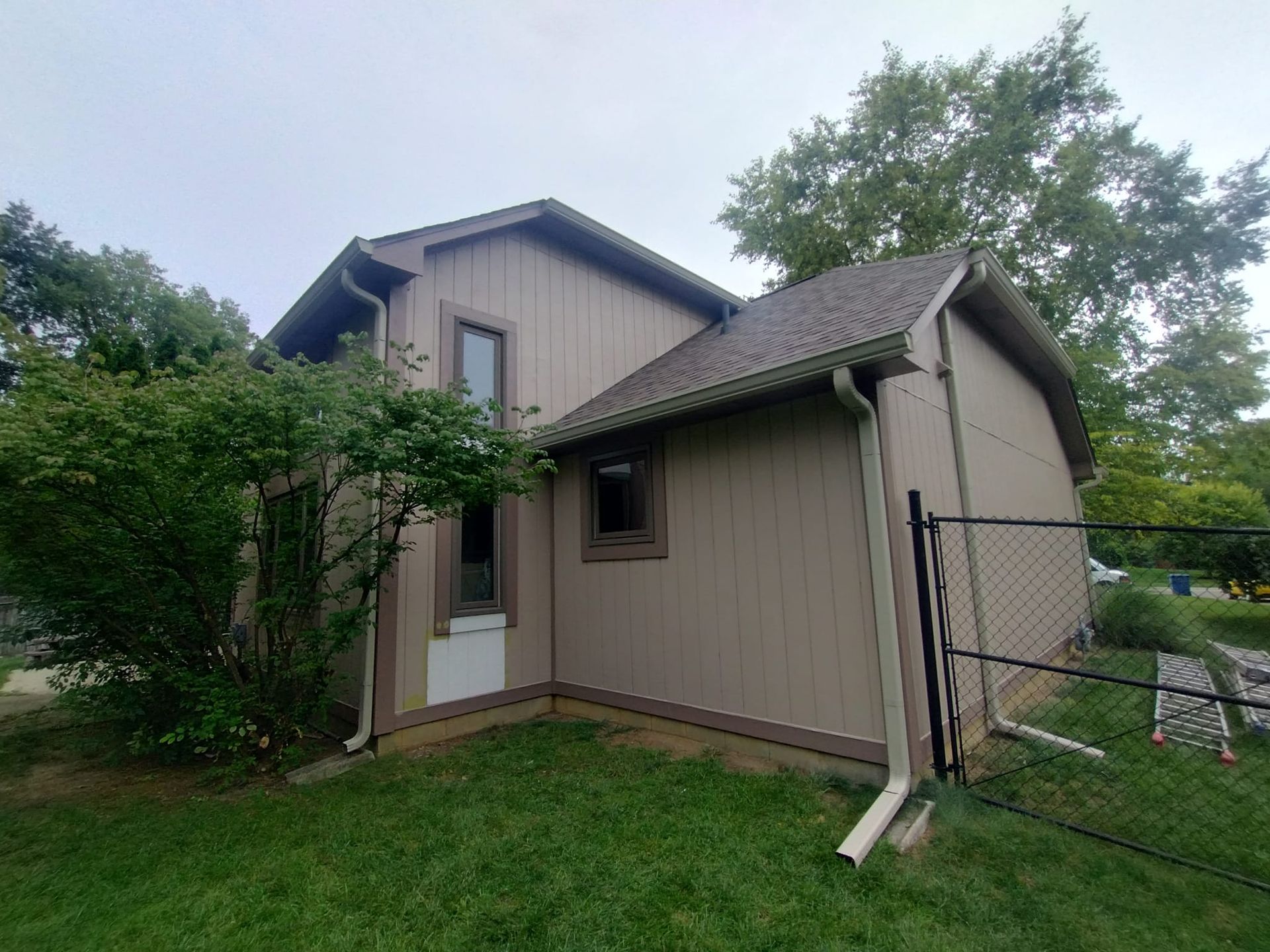 A house with a fence and a shed in the backyard.