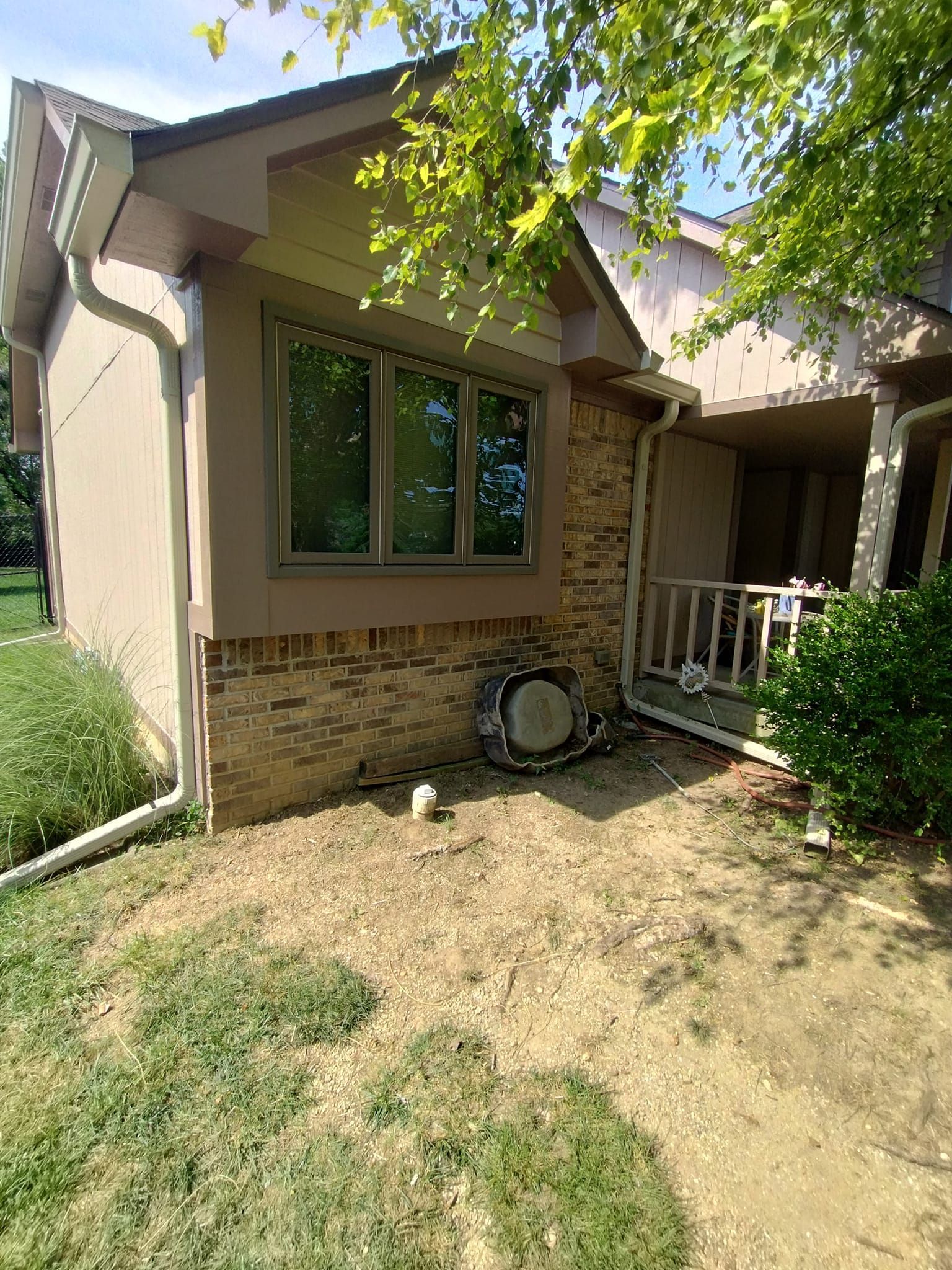 A house with a lot of windows and a tire on the ground in front of it.