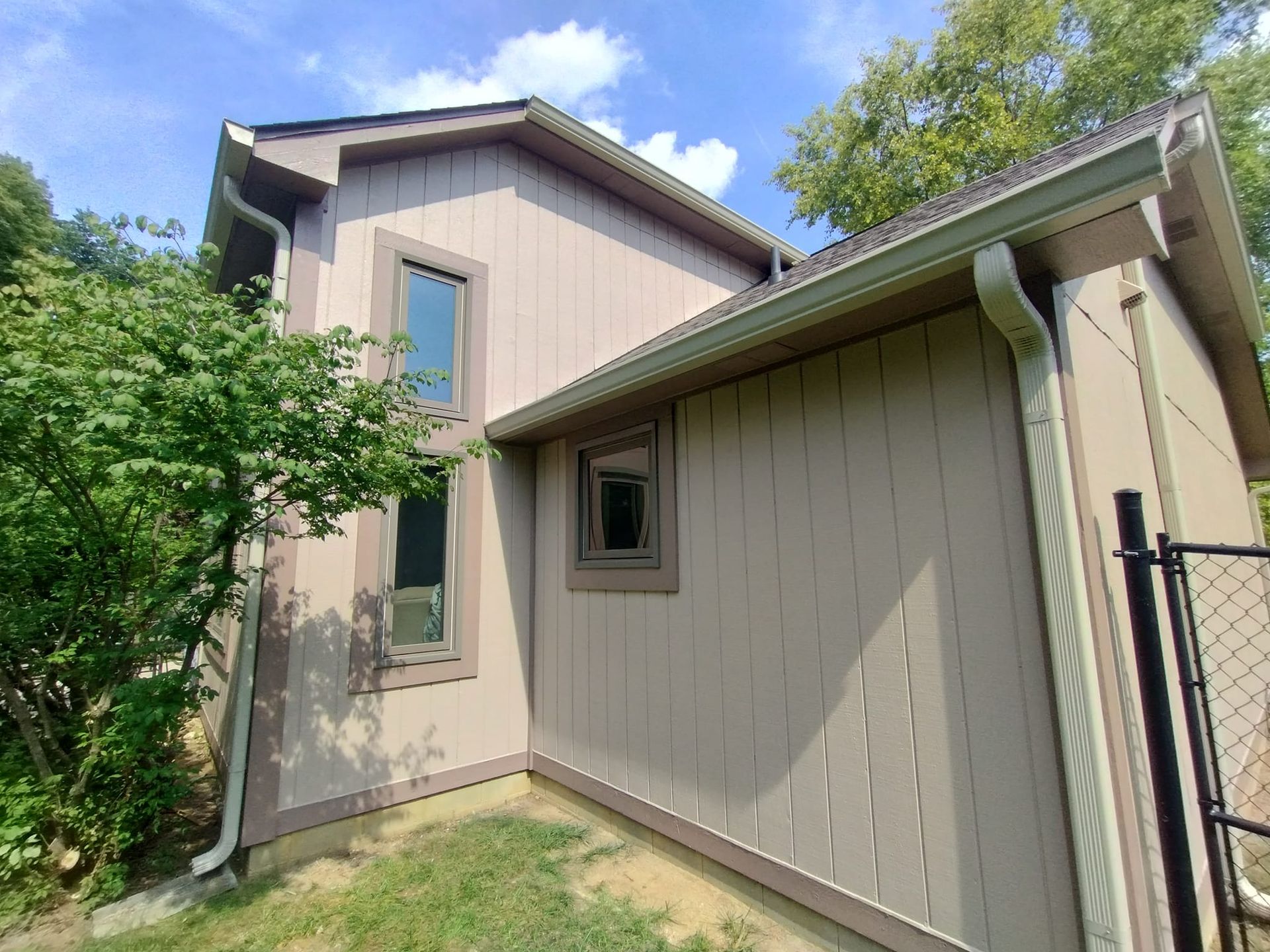 A house with a fence and a gutter on the side of it.