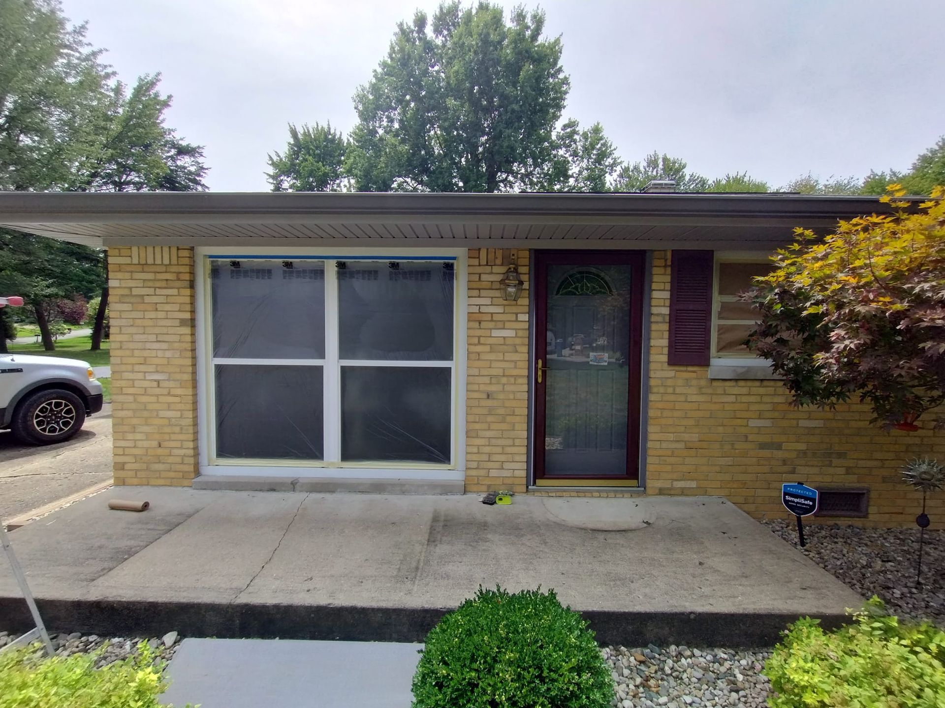 A brick house with a car parked in front of it.