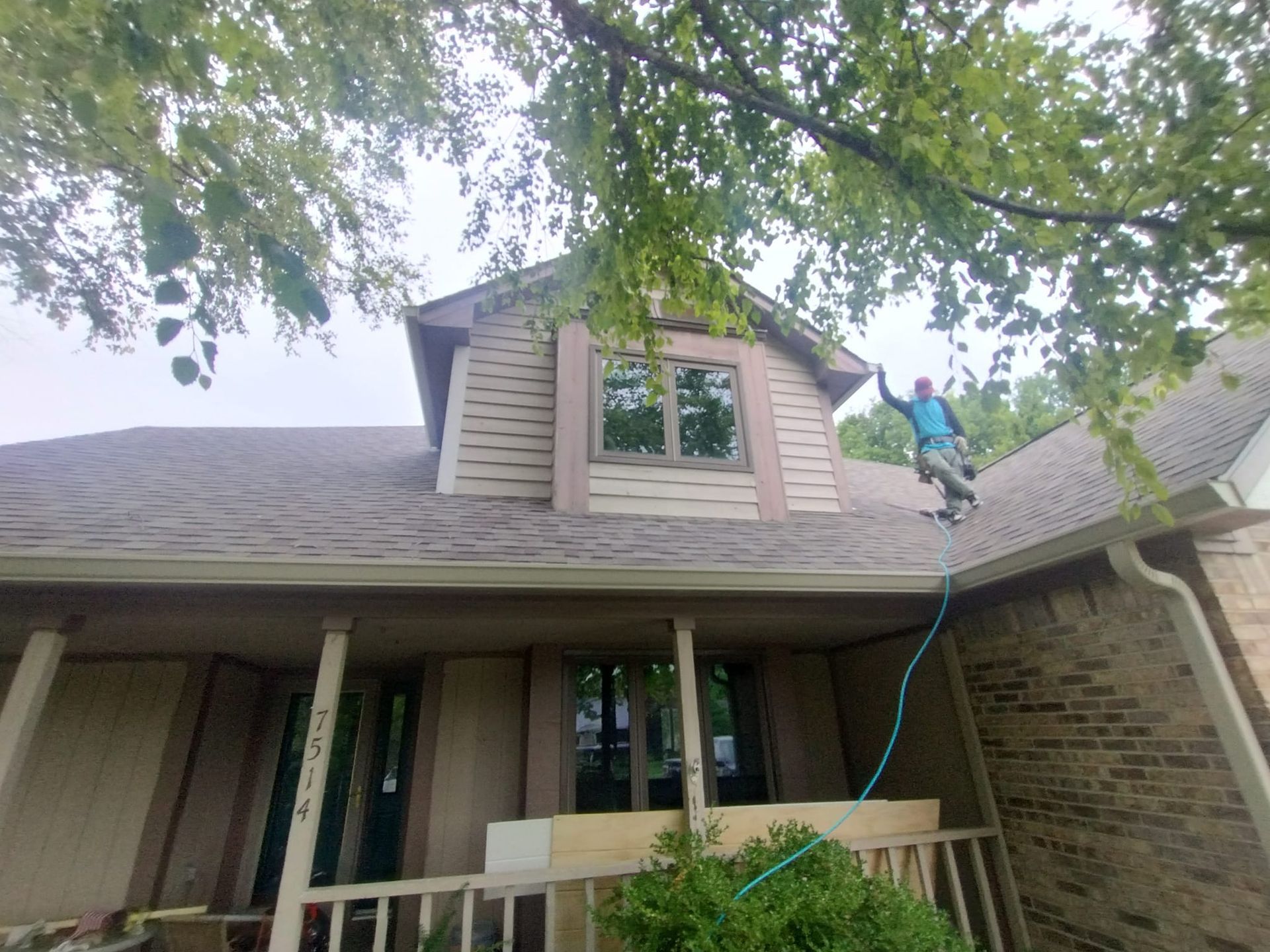A man is standing on the roof of a house.
