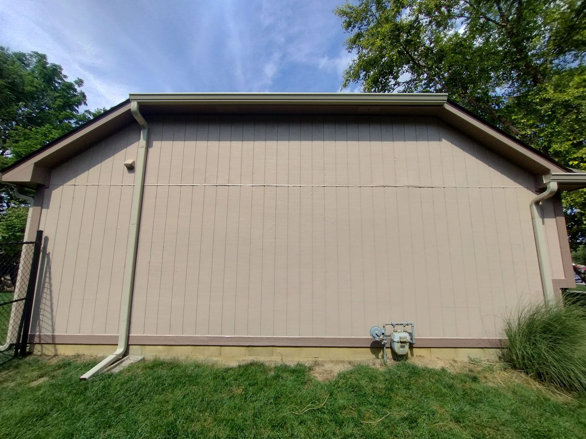 The side of a house with a gutter and a roof.