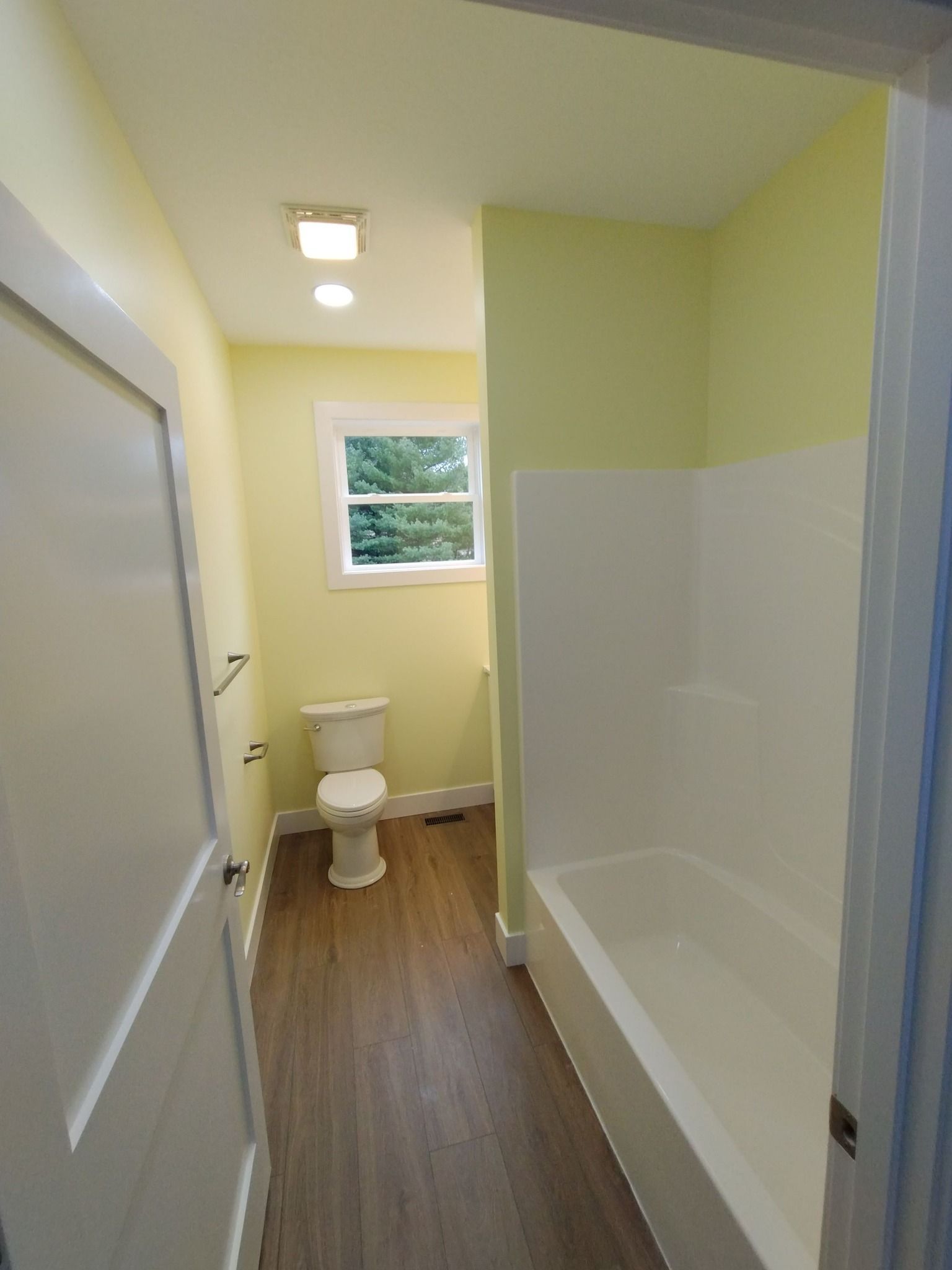 A bathroom with a toilet , tub and shower.