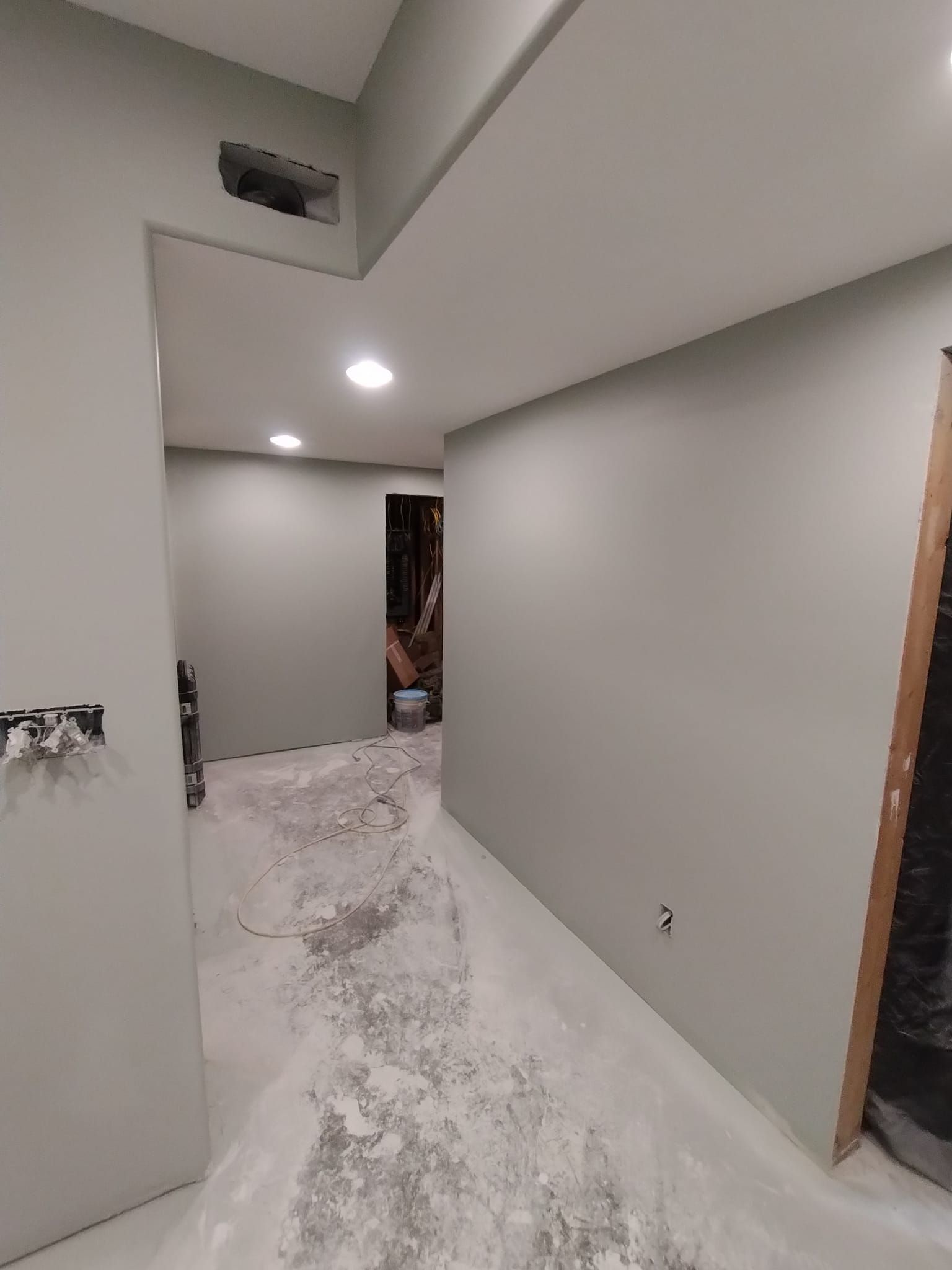 A hallway with a lot of dust on the floor and walls.