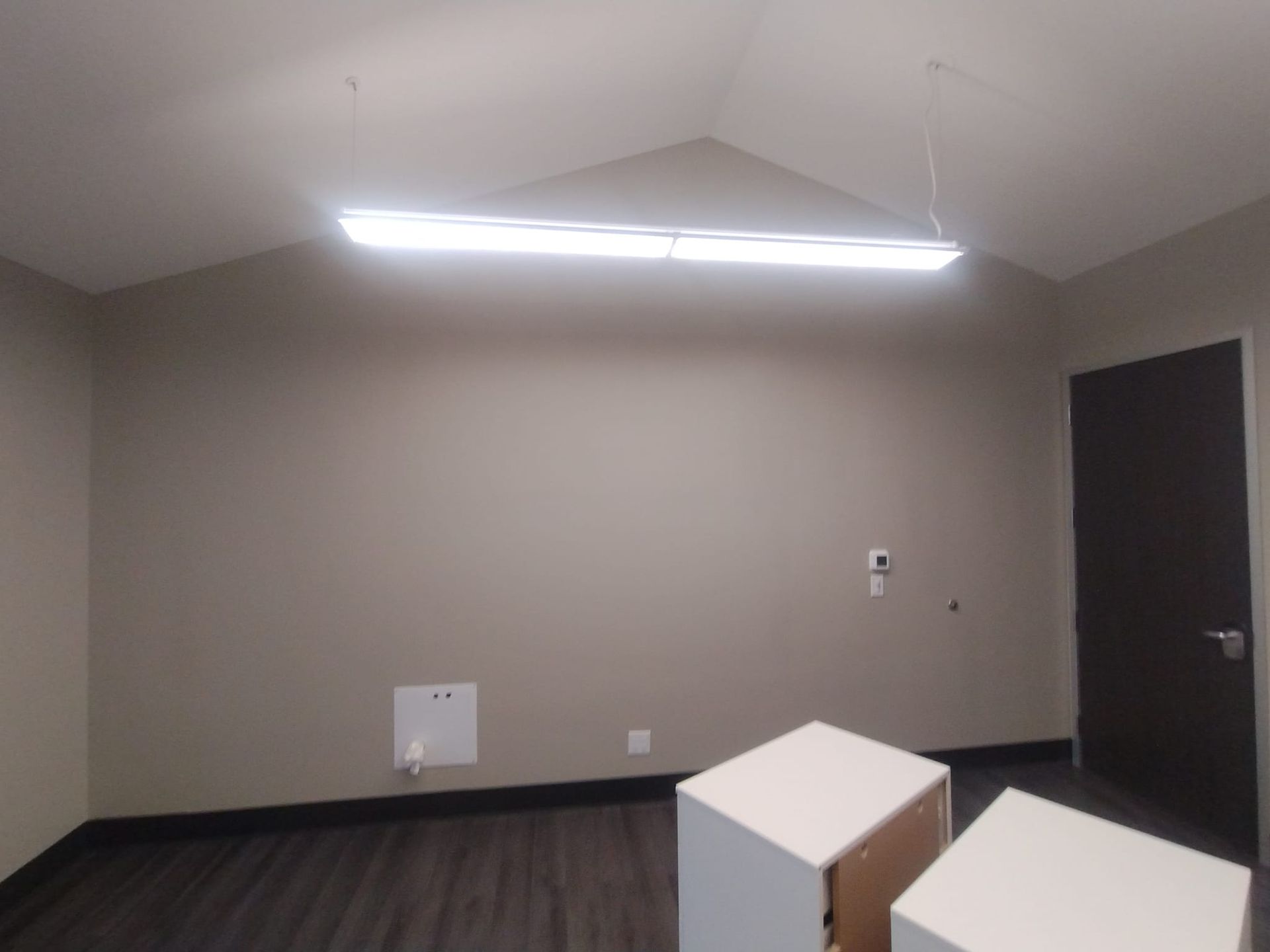 An empty room with a light hanging from the ceiling