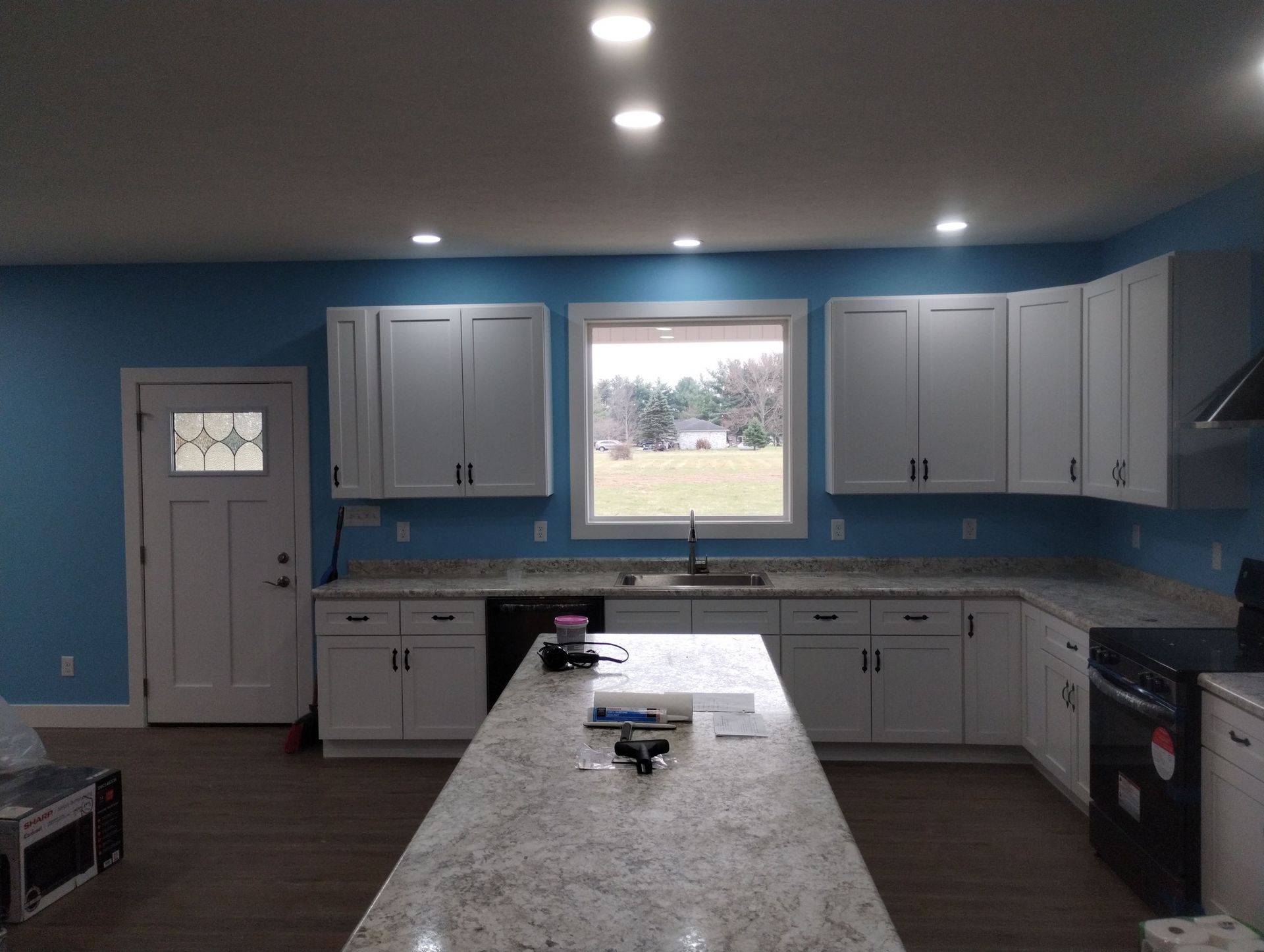 A kitchen with blue walls and white cabinets and a large island