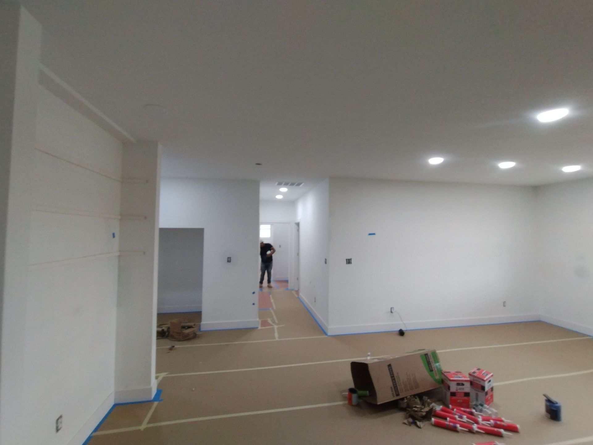 A large room with white walls and a ladder on the floor.