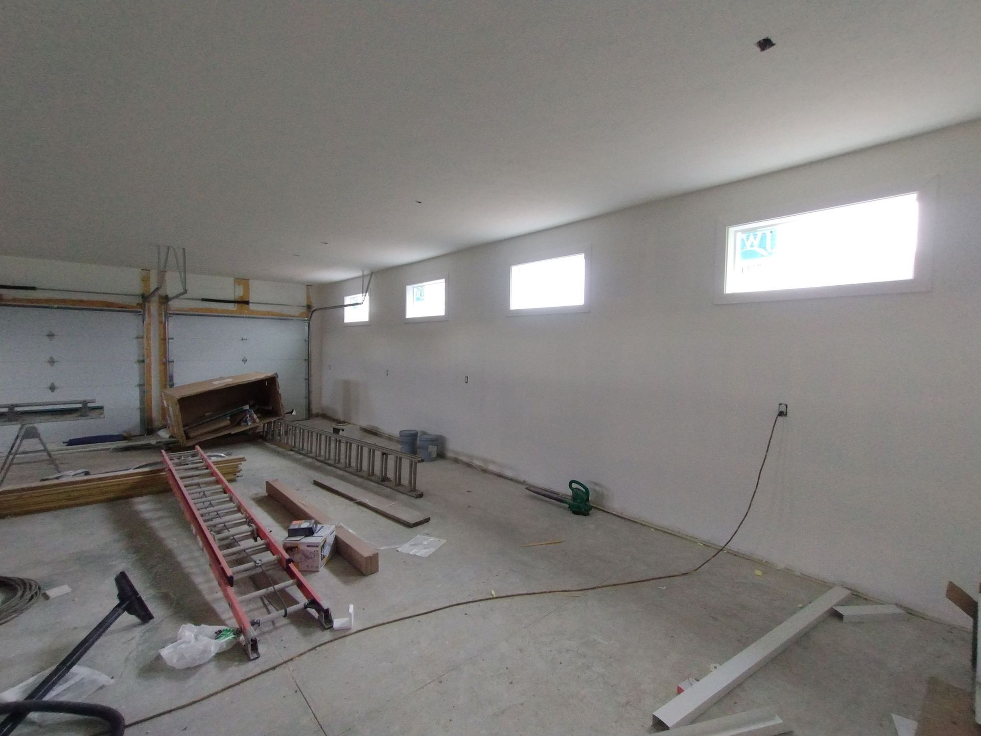 A room with a ladder and a vacuum cleaner in it.