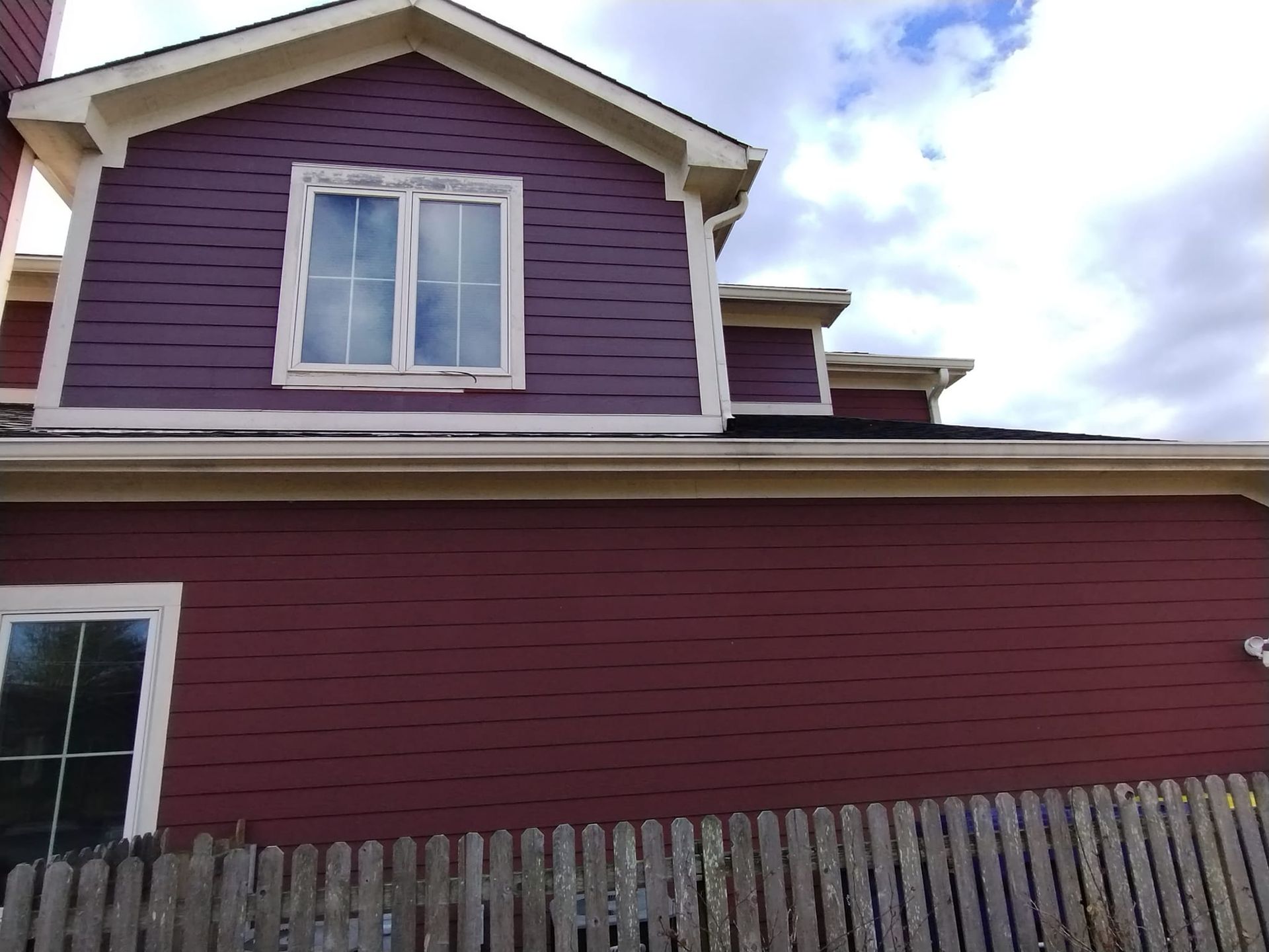 A red house with a wooden fence in front of it