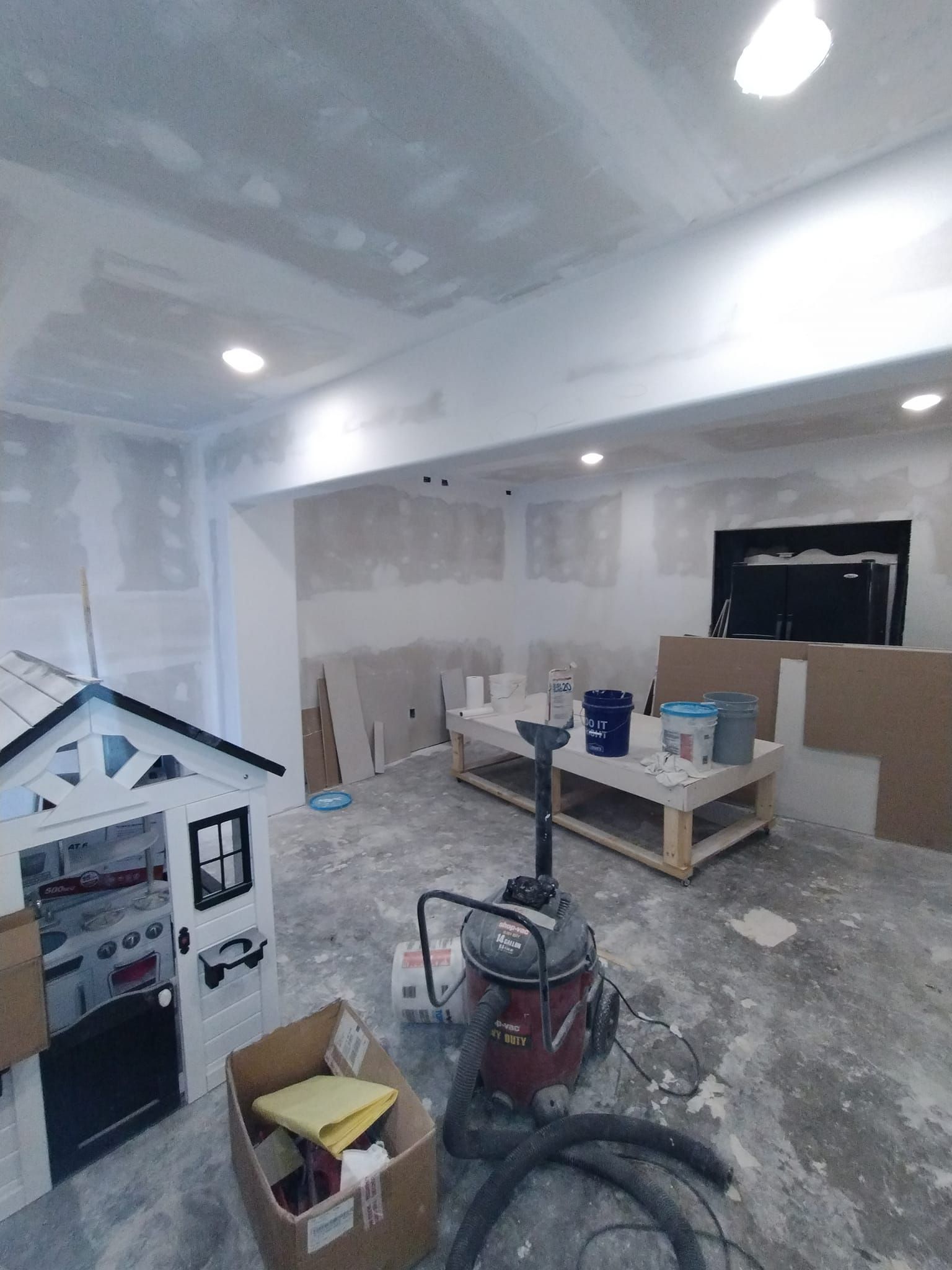 A vacuum cleaner is sitting in a room that is being remodeled.