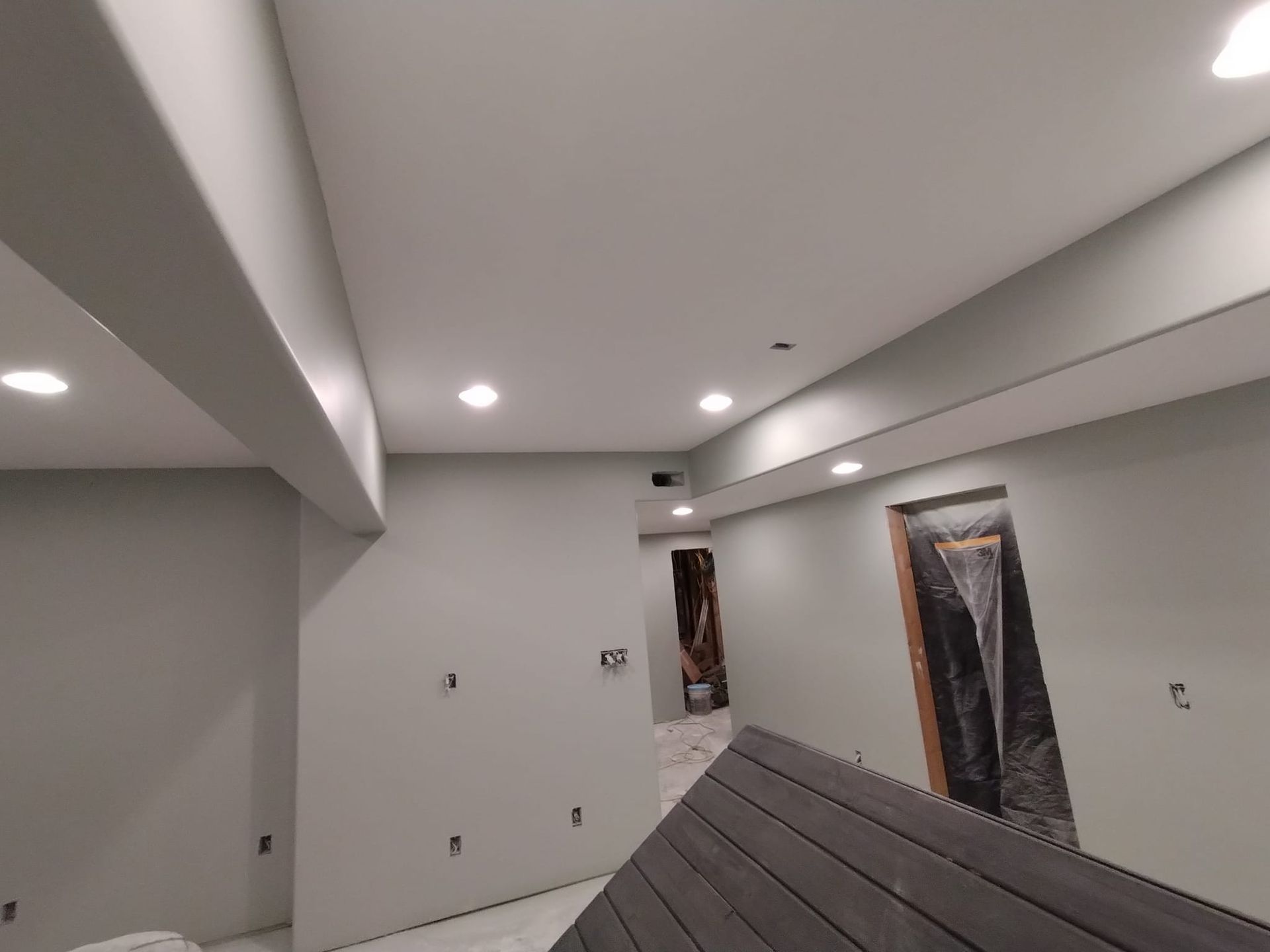 A room with a wooden floor and a ceiling that is being remodeled.