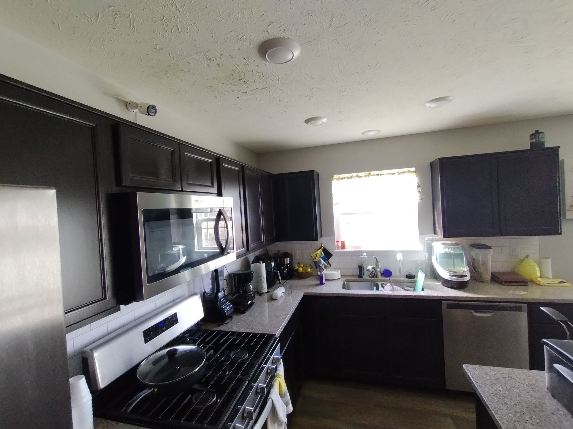 A kitchen with stainless steel appliances and black cabinets