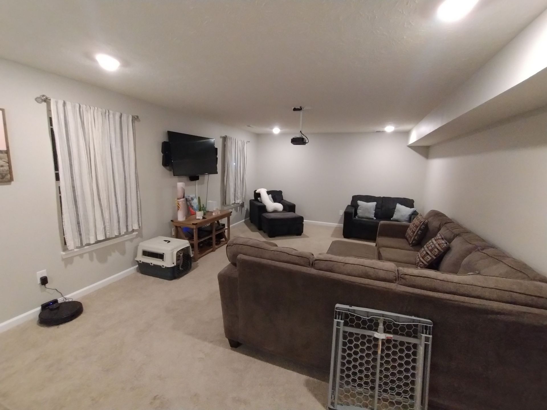 A living room with a couch , chairs , and a television.