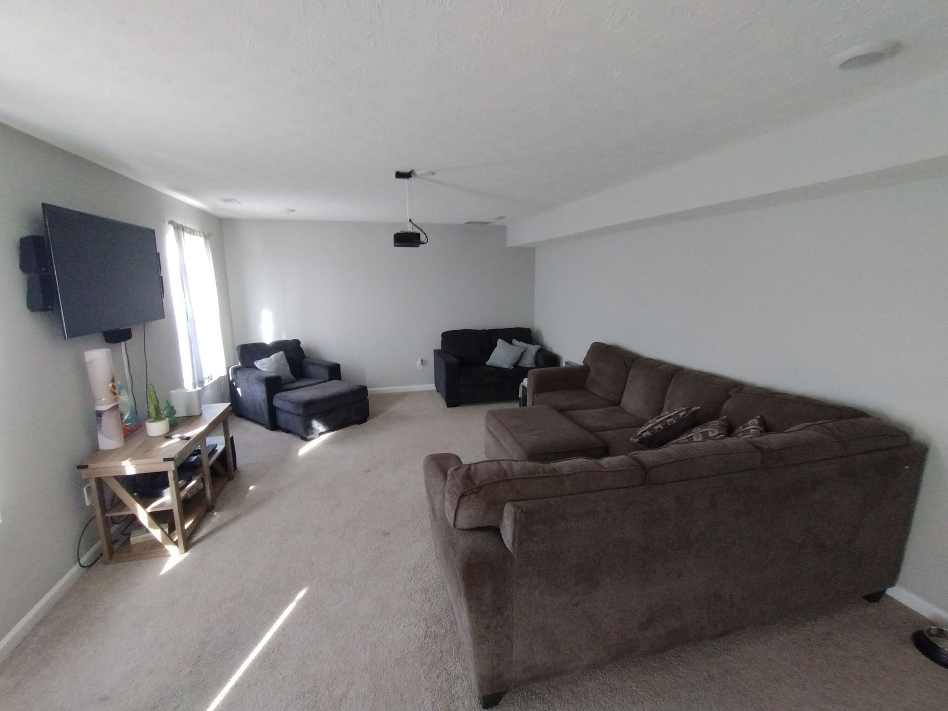 A living room with a couch , chair , table and television.