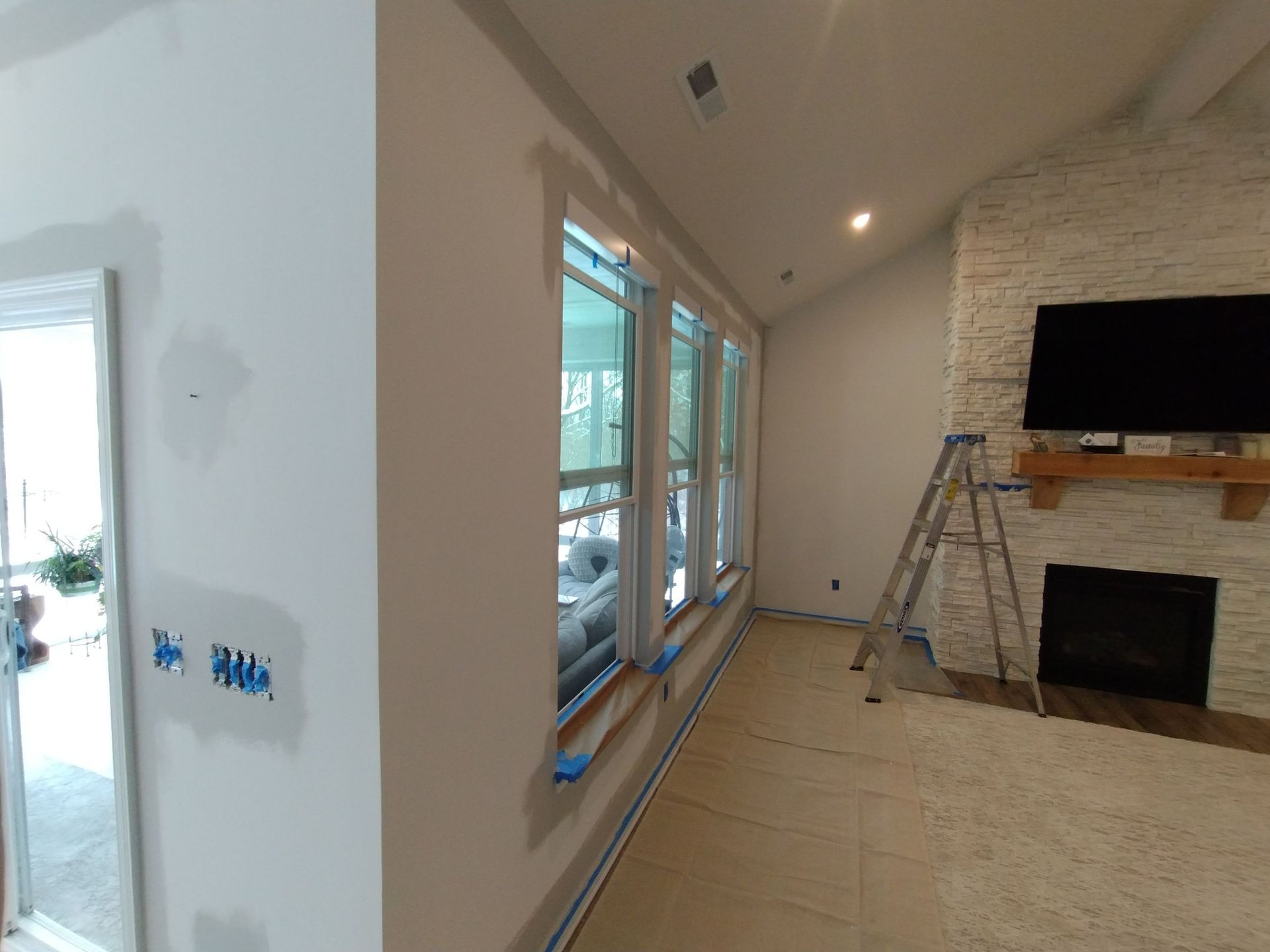 A living room with a fireplace and a television on the wall.