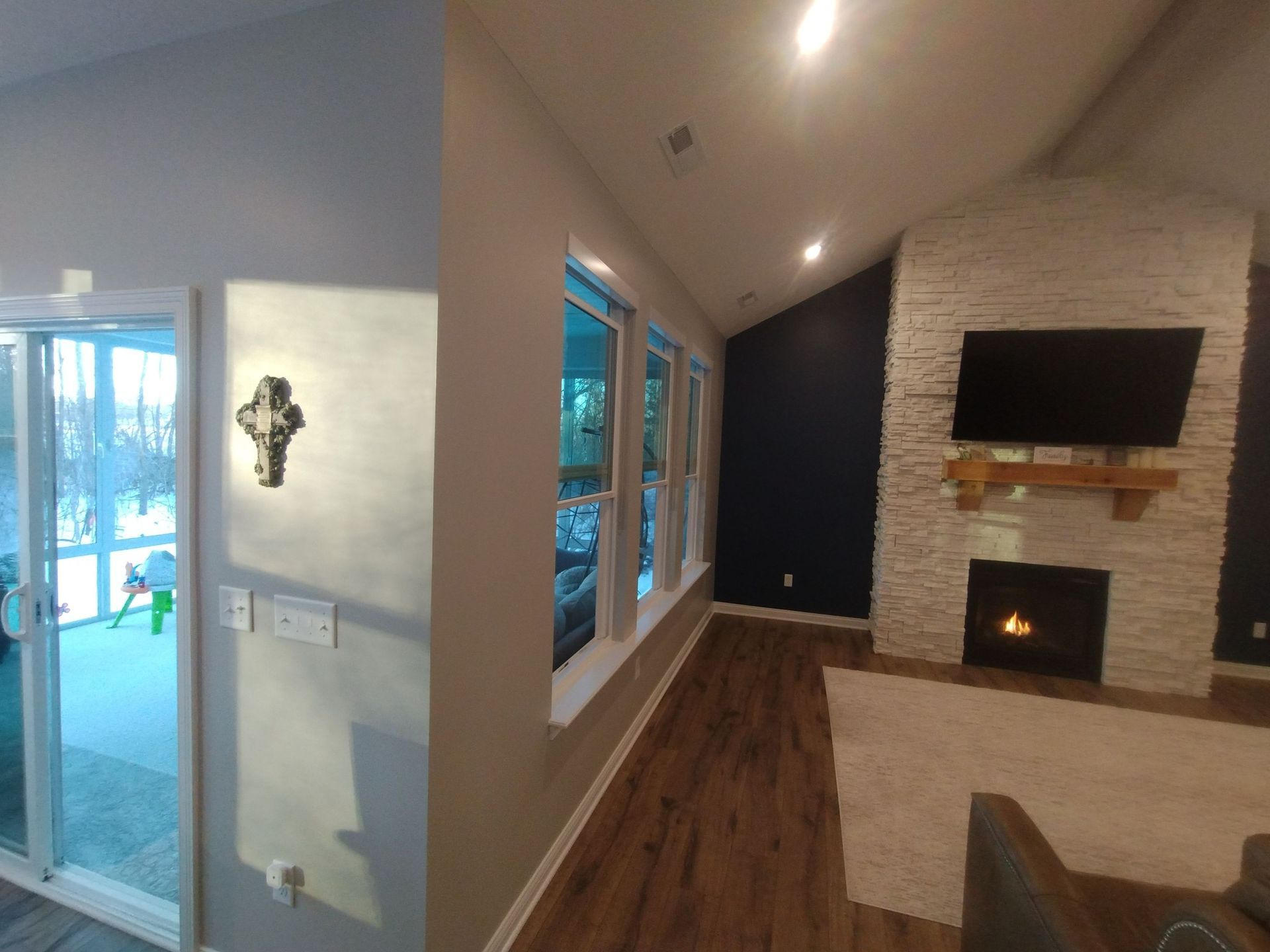 A living room with a fireplace and a television on the wall