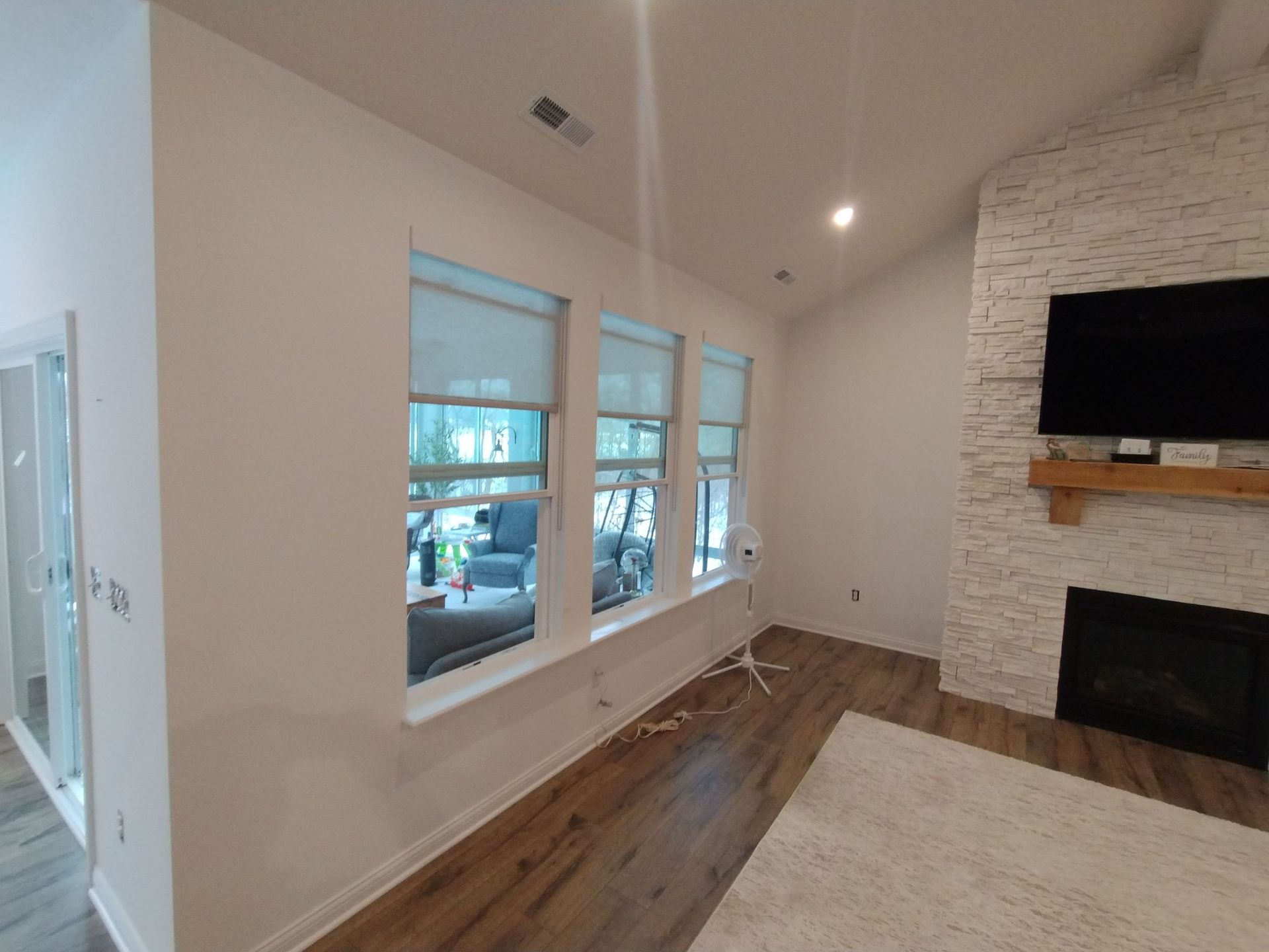 A living room with a fireplace and a flat screen tv.