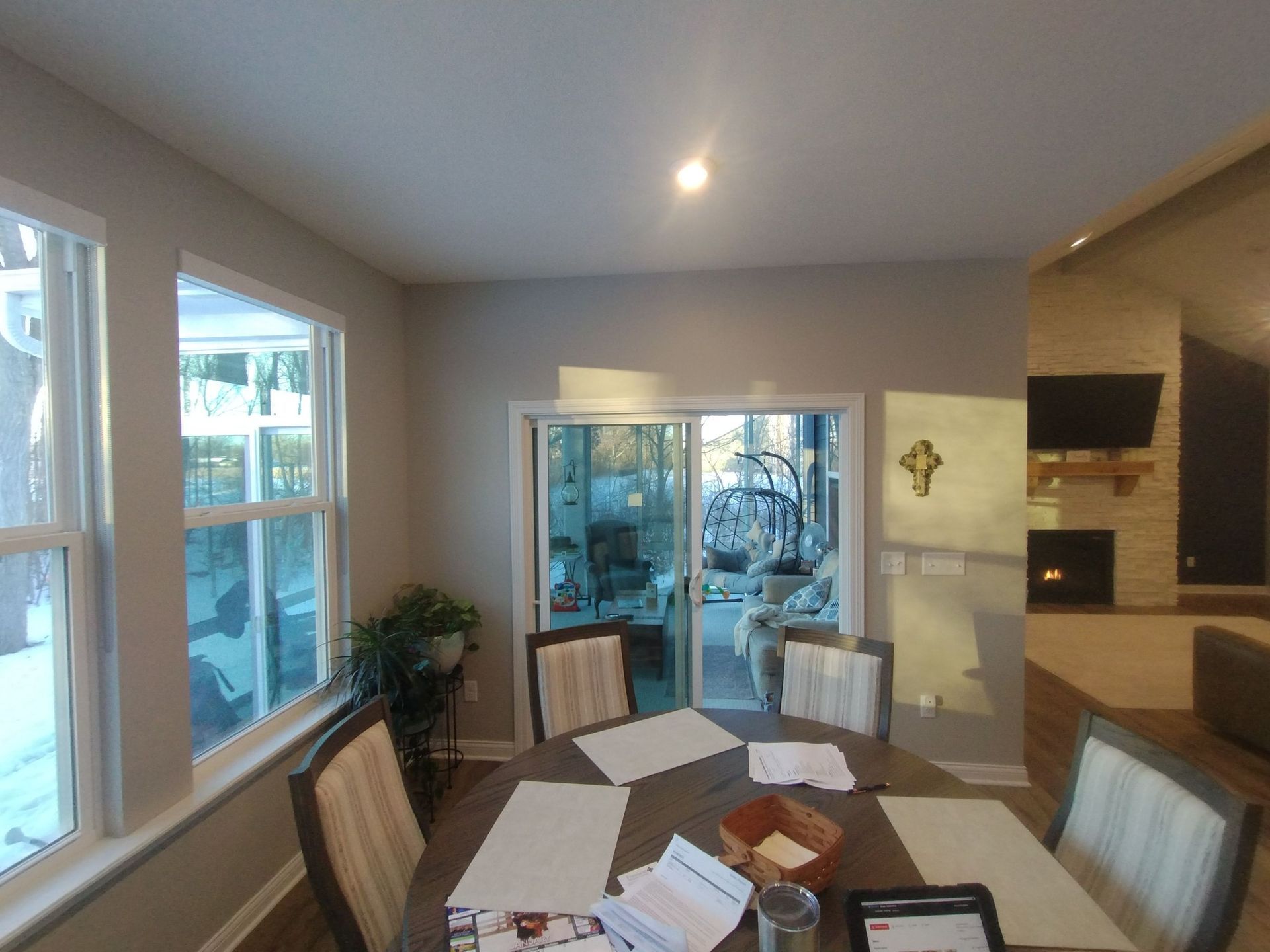 A dining room with a table and chairs and a sliding glass door