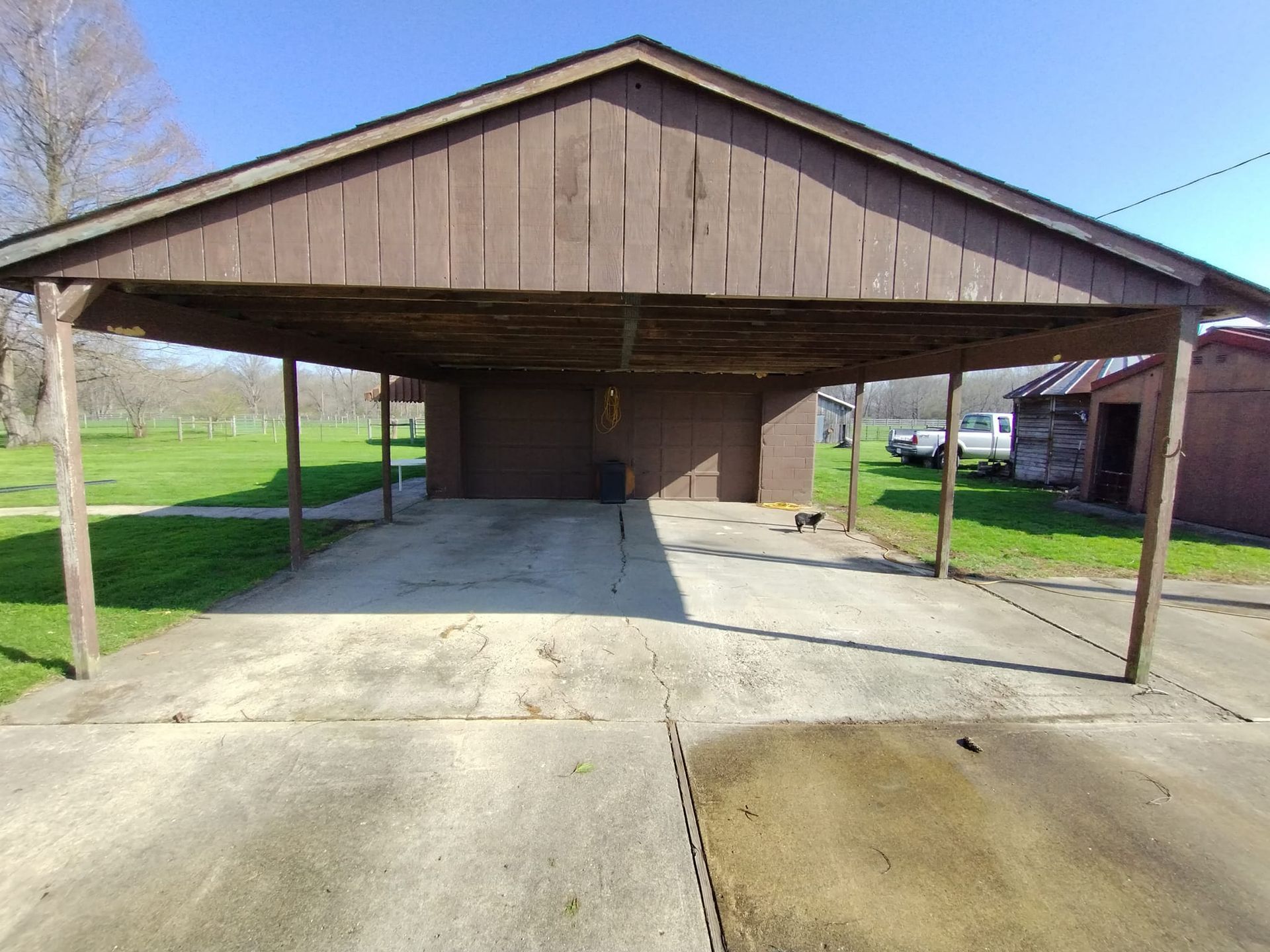 A carport with a concrete driveway underneath it