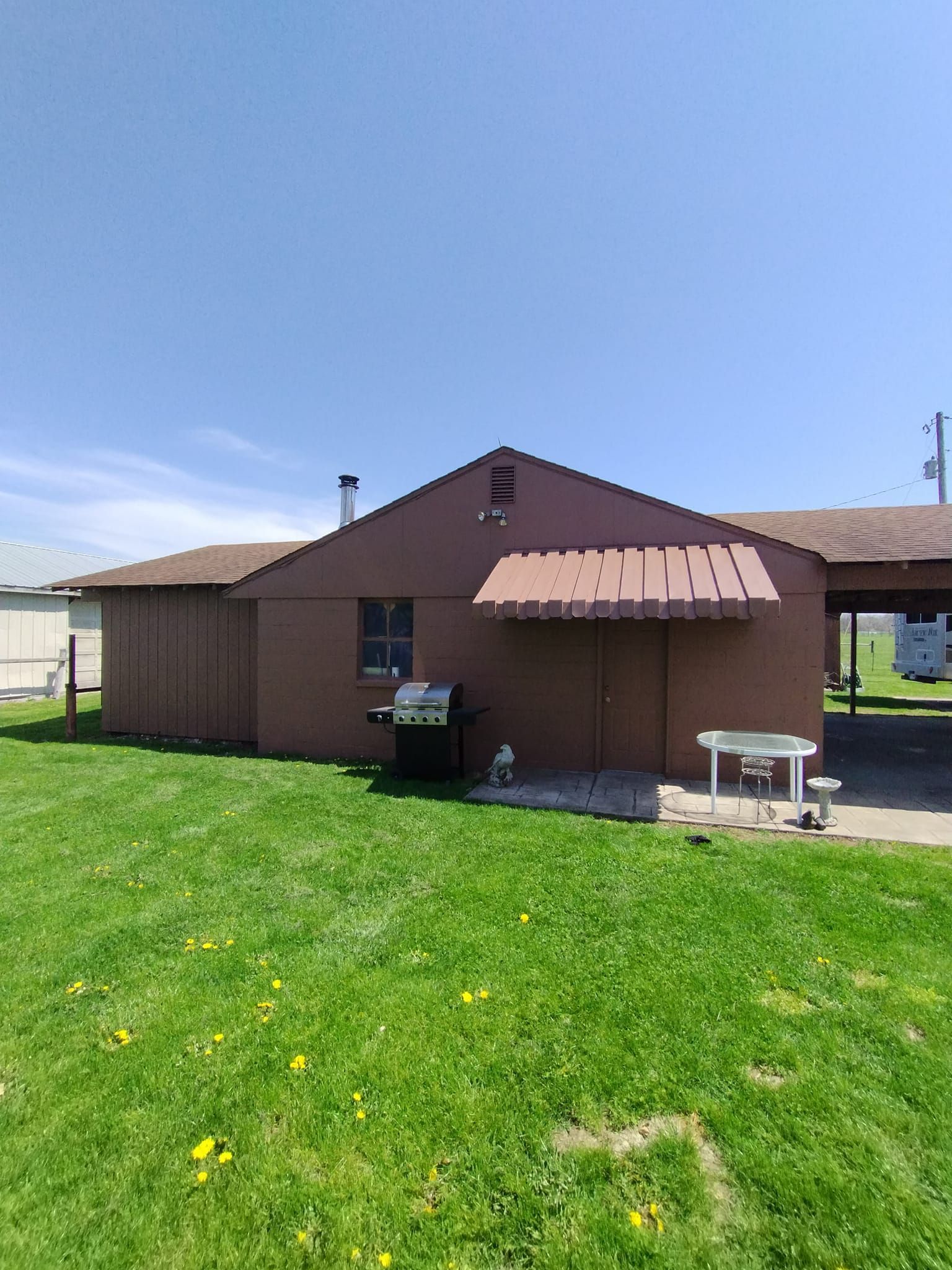 A house with a bbq and a table in front of it.