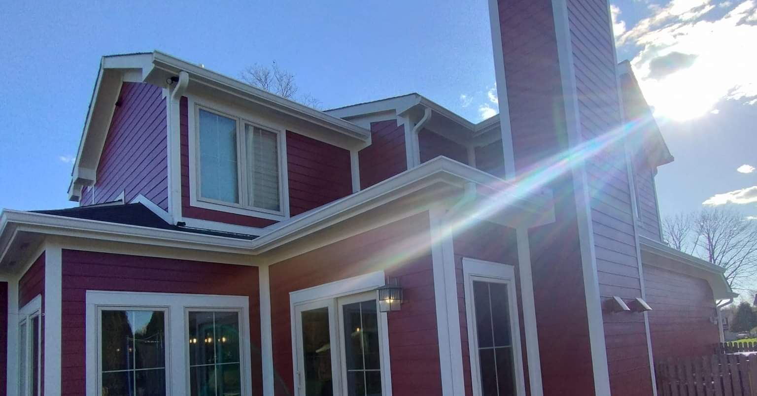 The sun is shining through the windows of a red house.