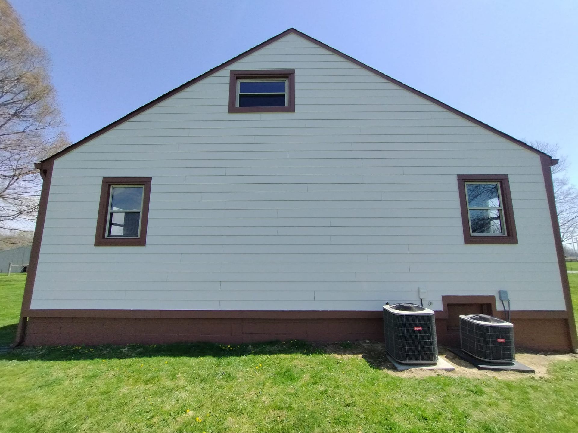 A house with two air conditioners on the side of it