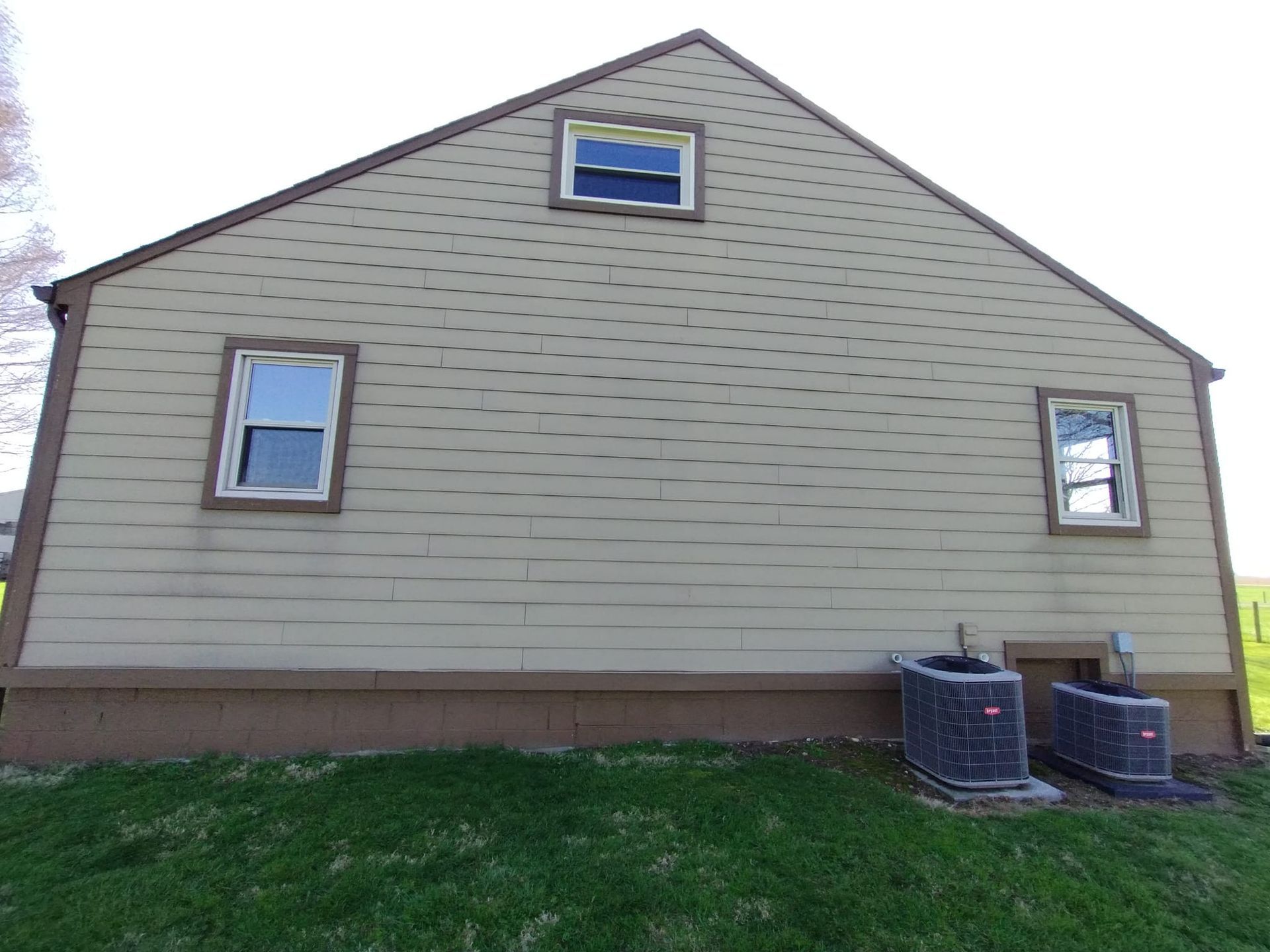 A house with two air conditioners on the side of it