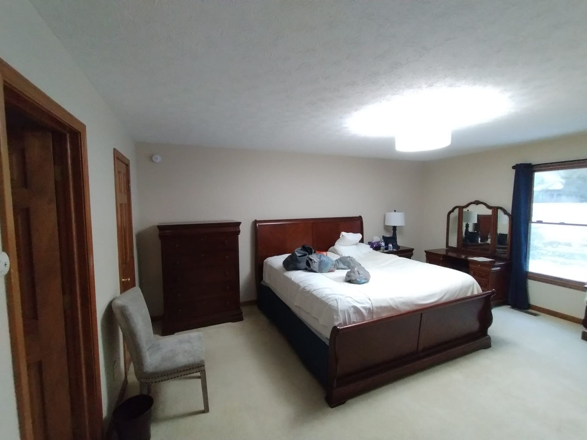 A bedroom with a large bed and a window