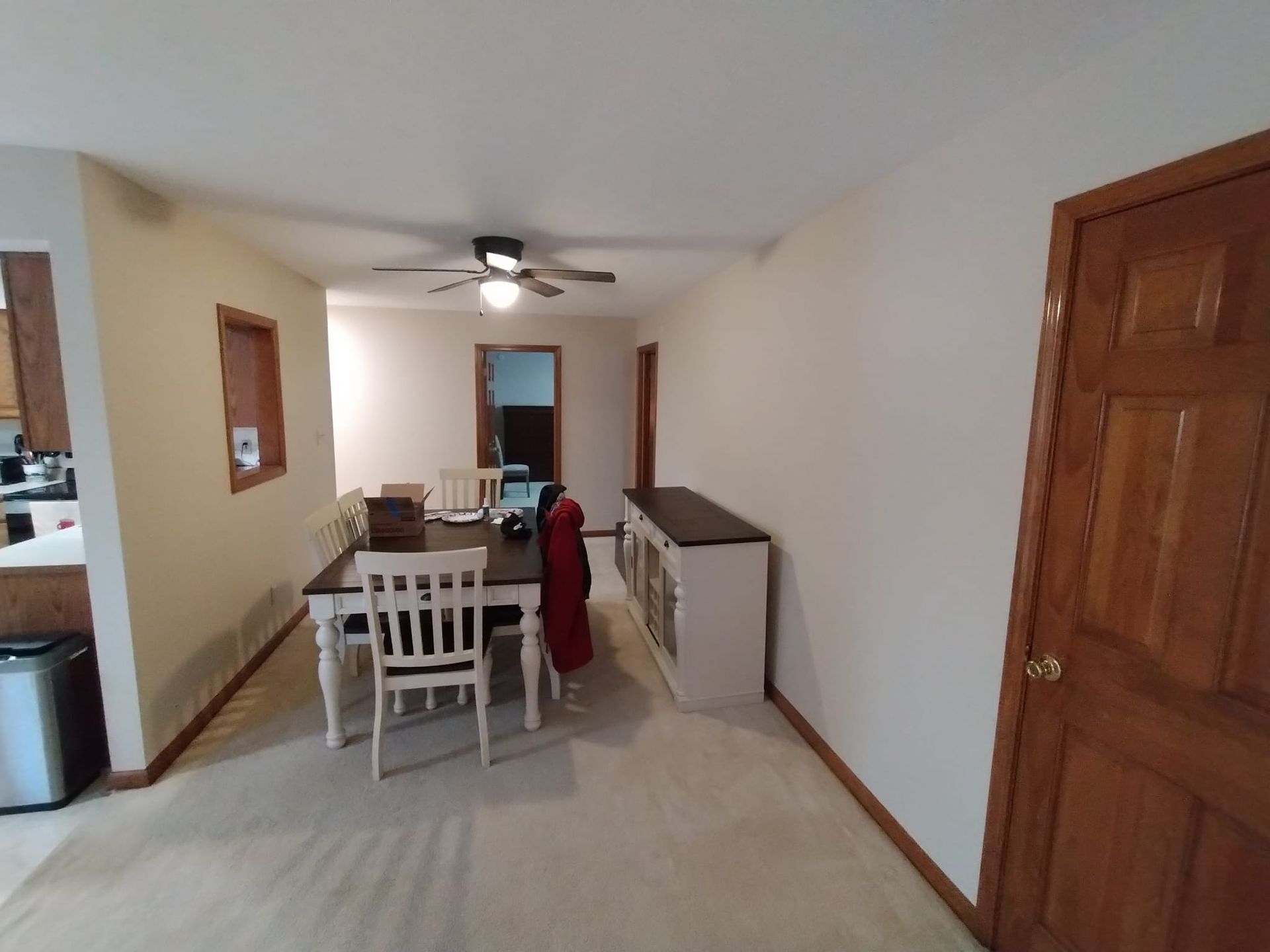 A dining room with a table and chairs and a ceiling fan
