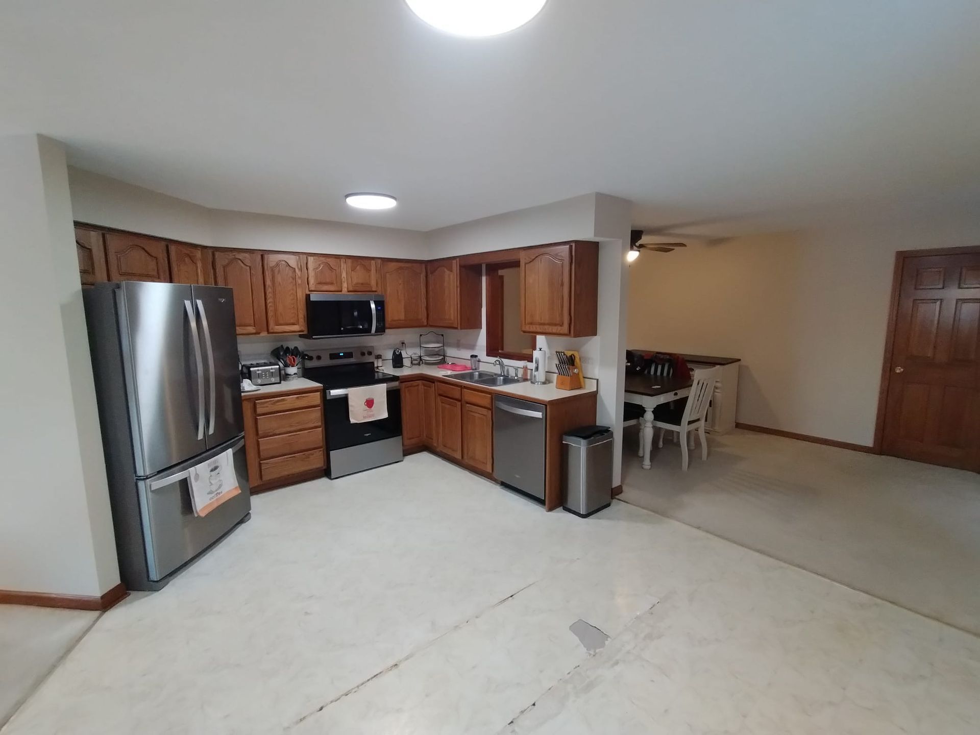 A kitchen with stainless steel appliances and wooden cabinets.