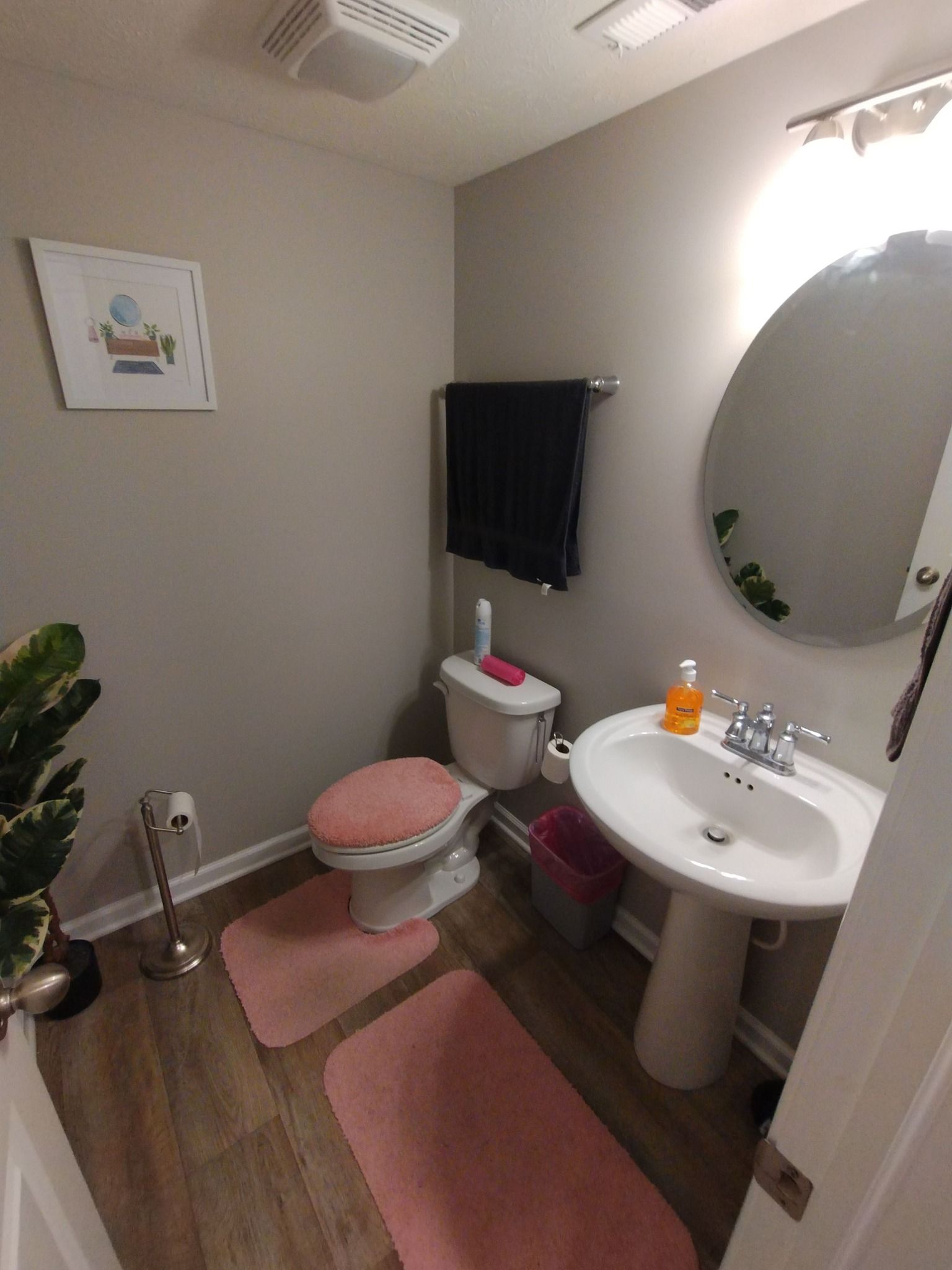 A bathroom with a toilet , sink , and mirror.