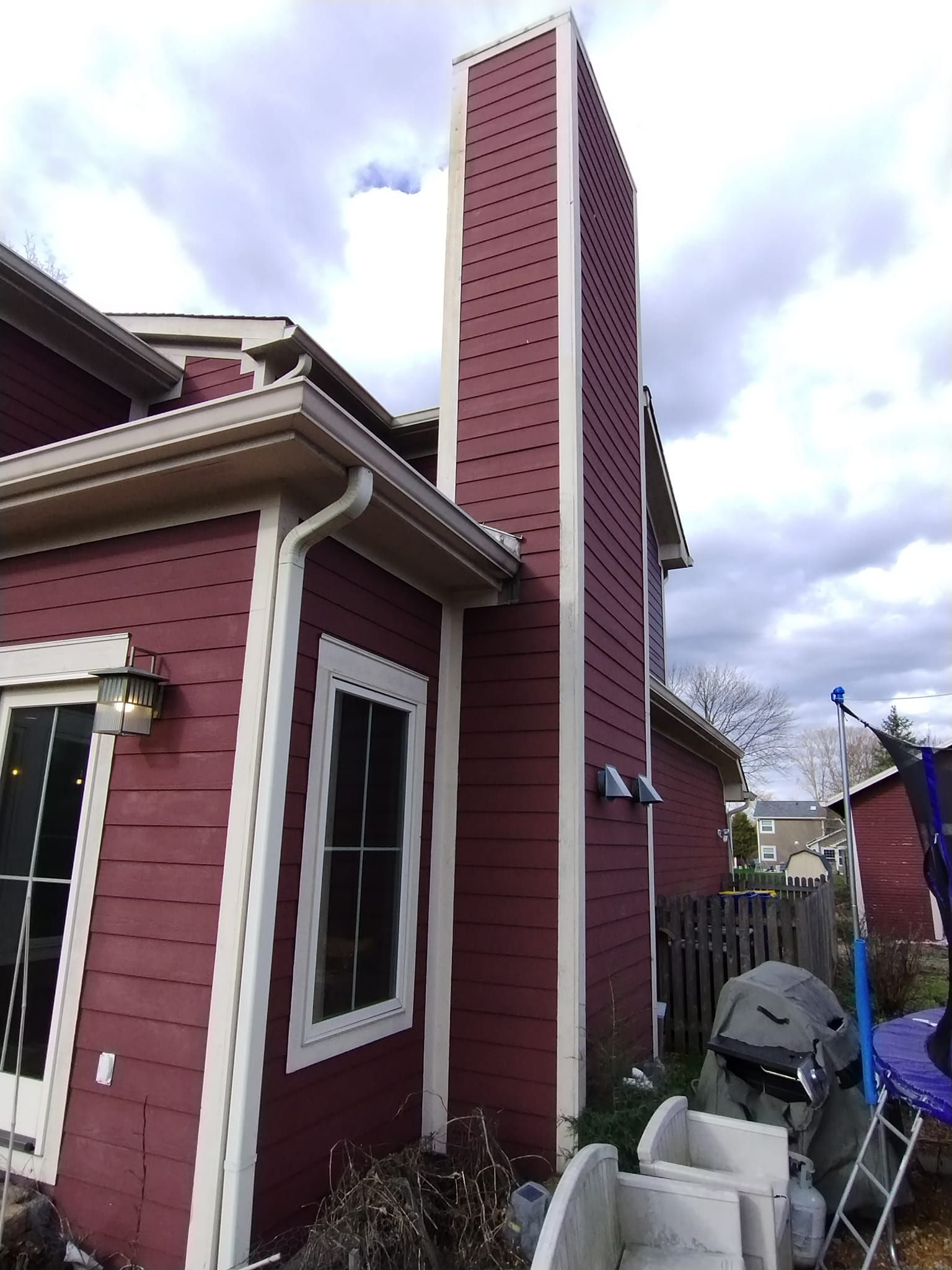 A red house with a chimney on the side of it