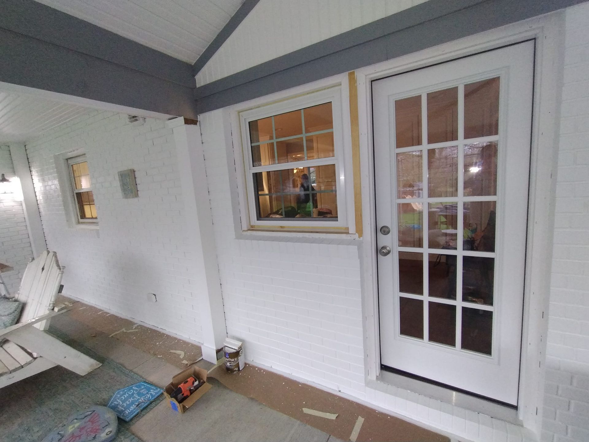 A white house with a french door and a window.