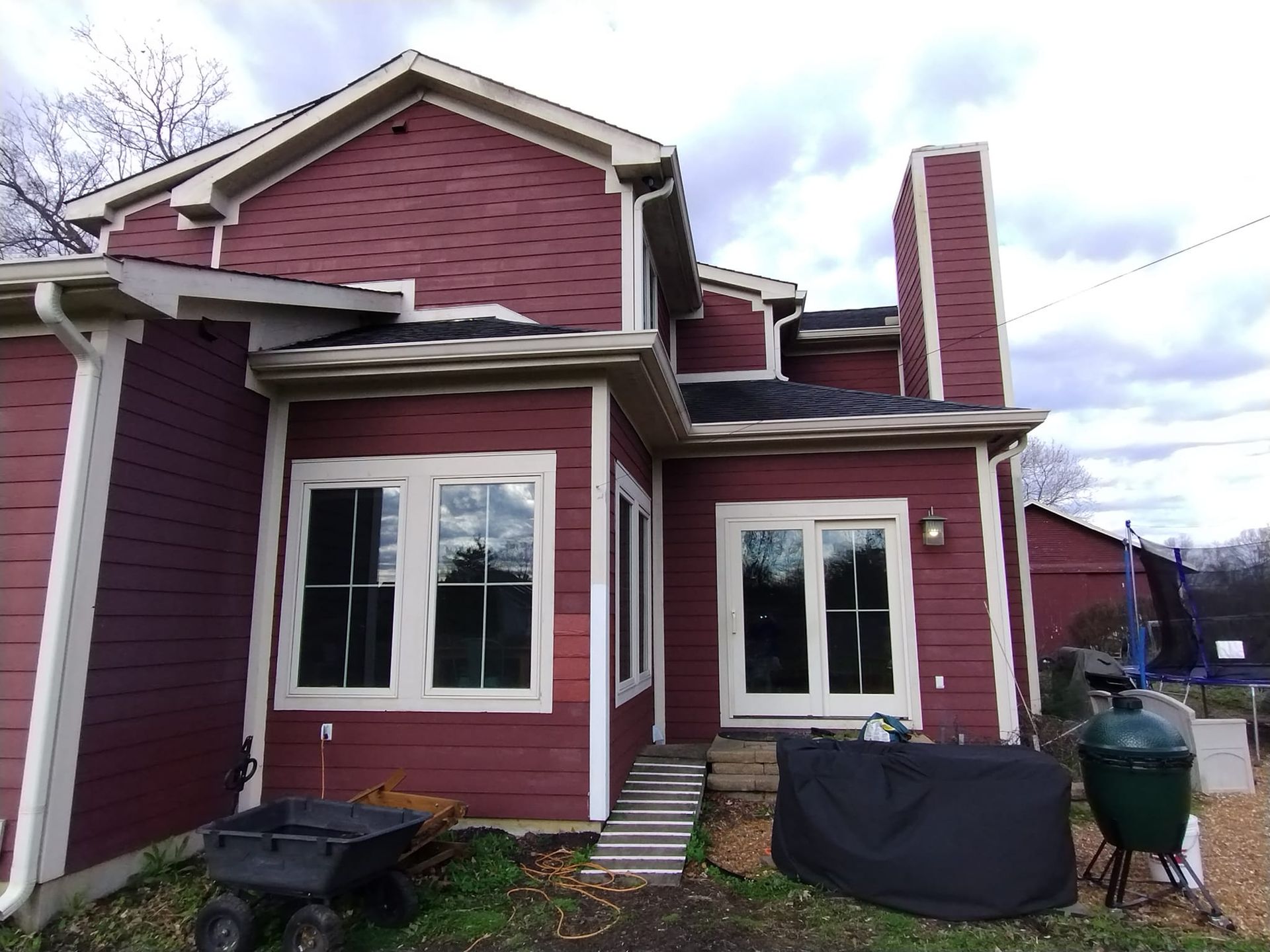 A large red house with a wheelbarrow in front of it