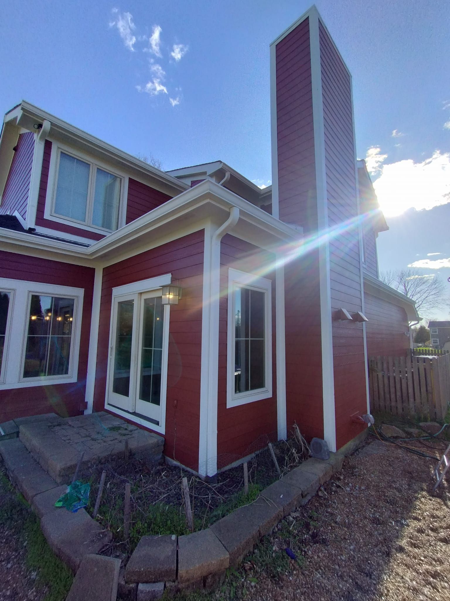 A red house with white trim and a chimney on the side.