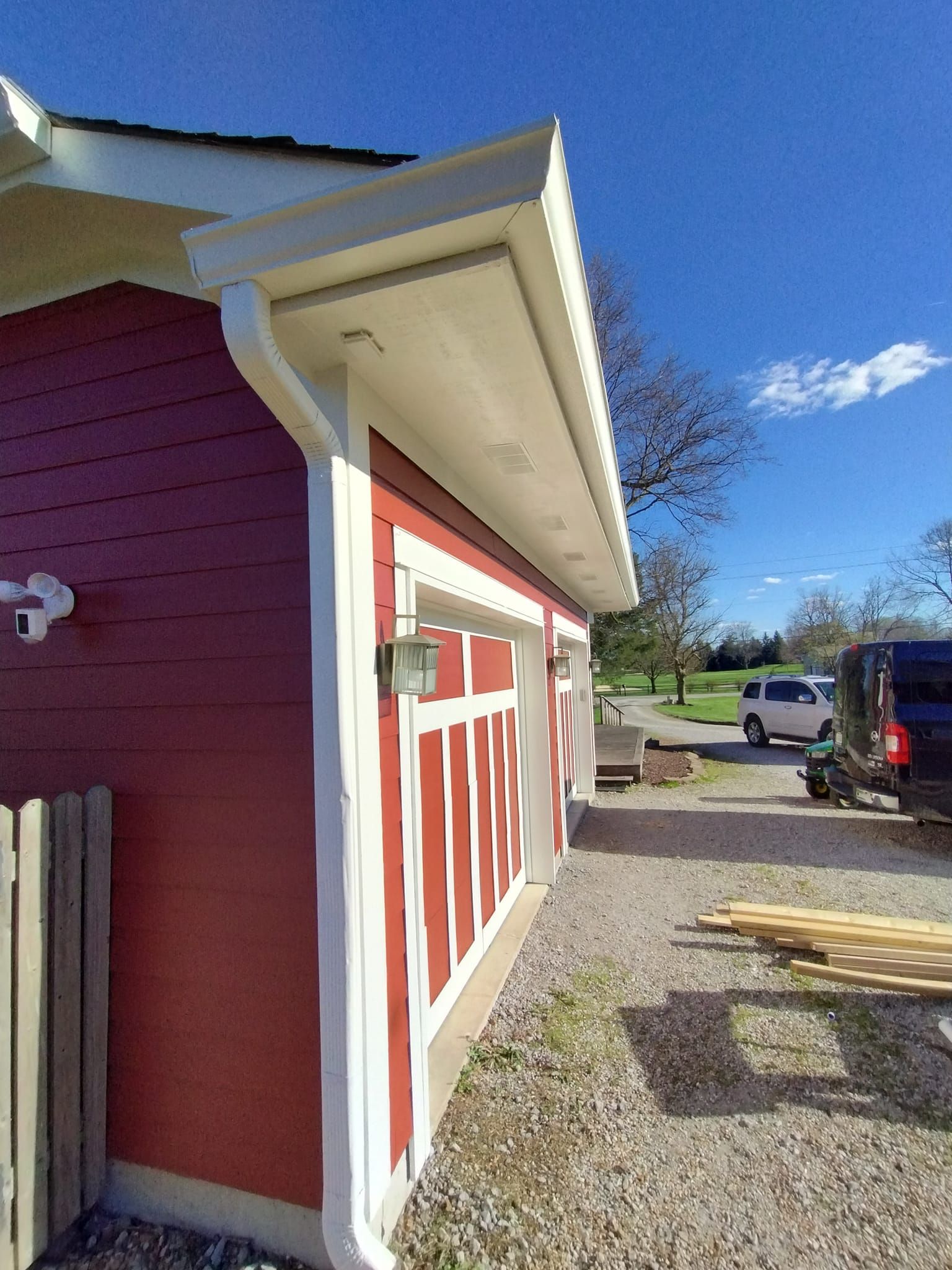 A red and white house with a white gutter on the side of it.