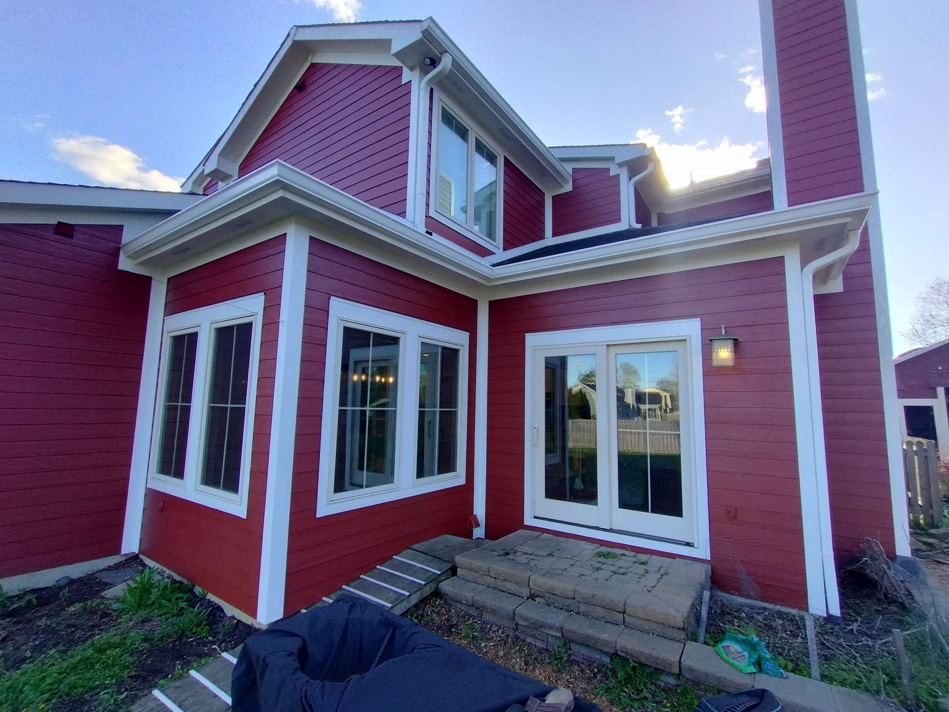 A red house with white trim and a lot of windows