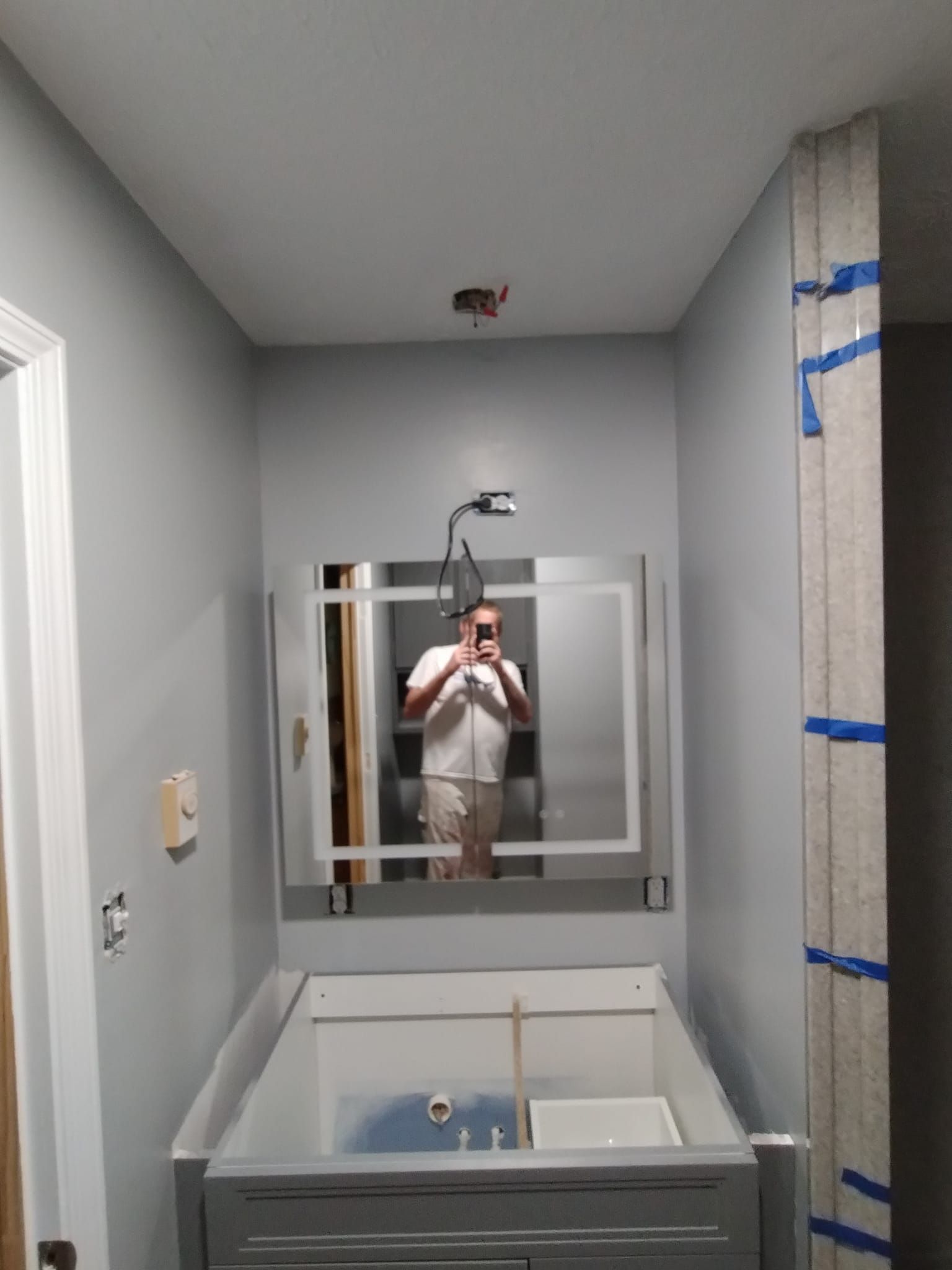 A man is taking a picture of himself in a bathroom mirror.