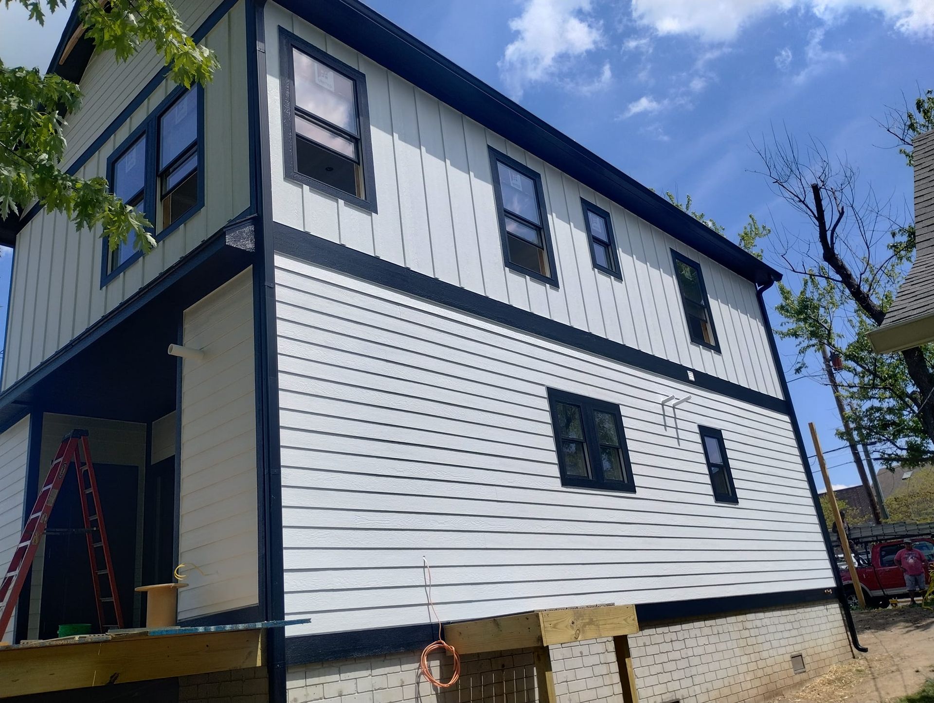 A white house with black trim is being built.