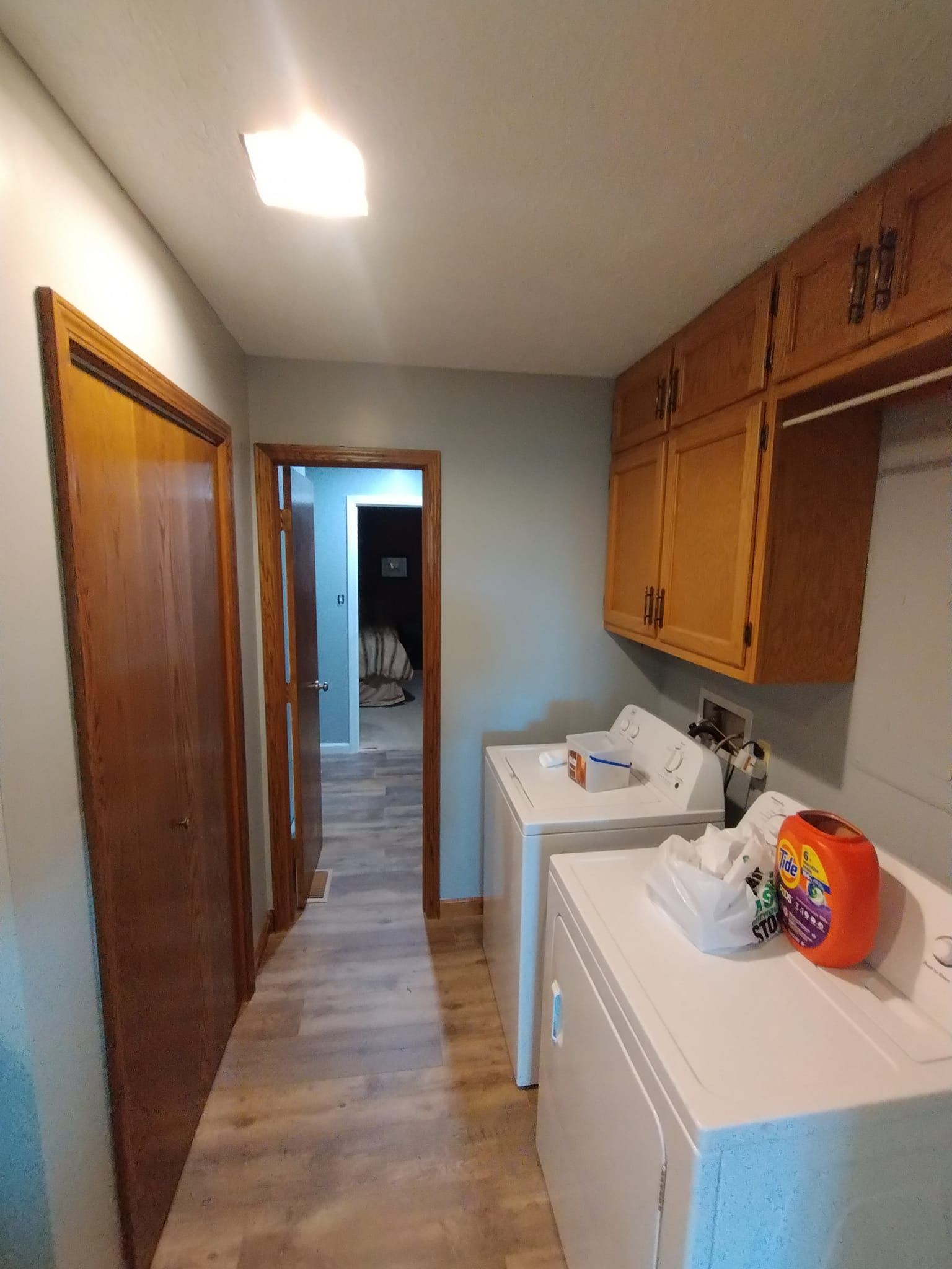 A laundry room with a washer and dryer and wooden cabinets.