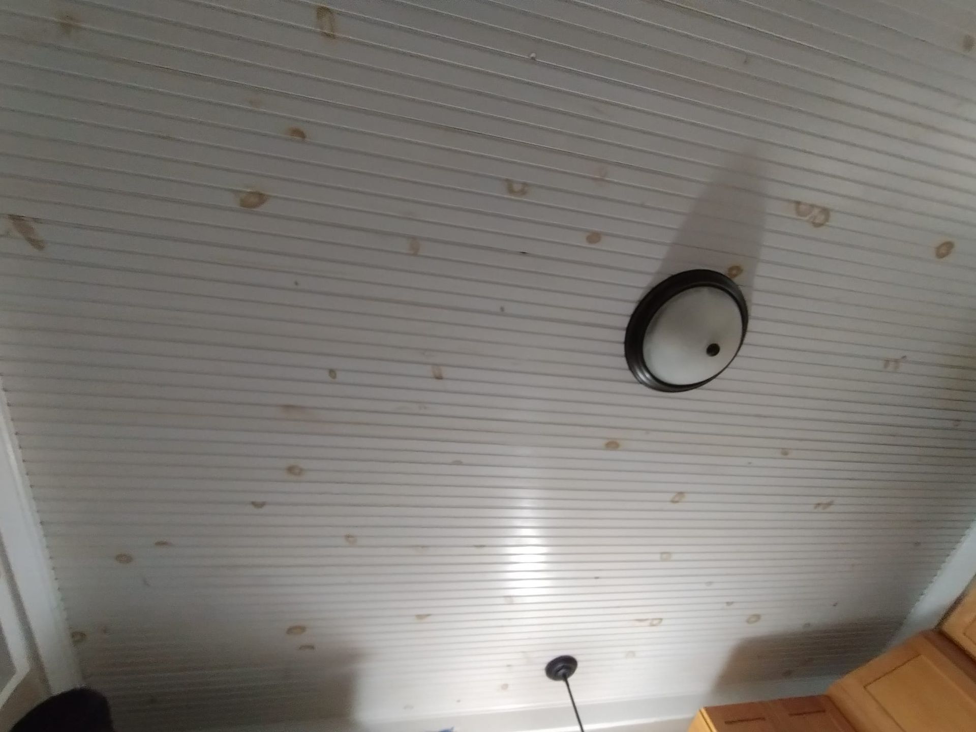 A white ceiling with a light hanging from it in a kitchen.