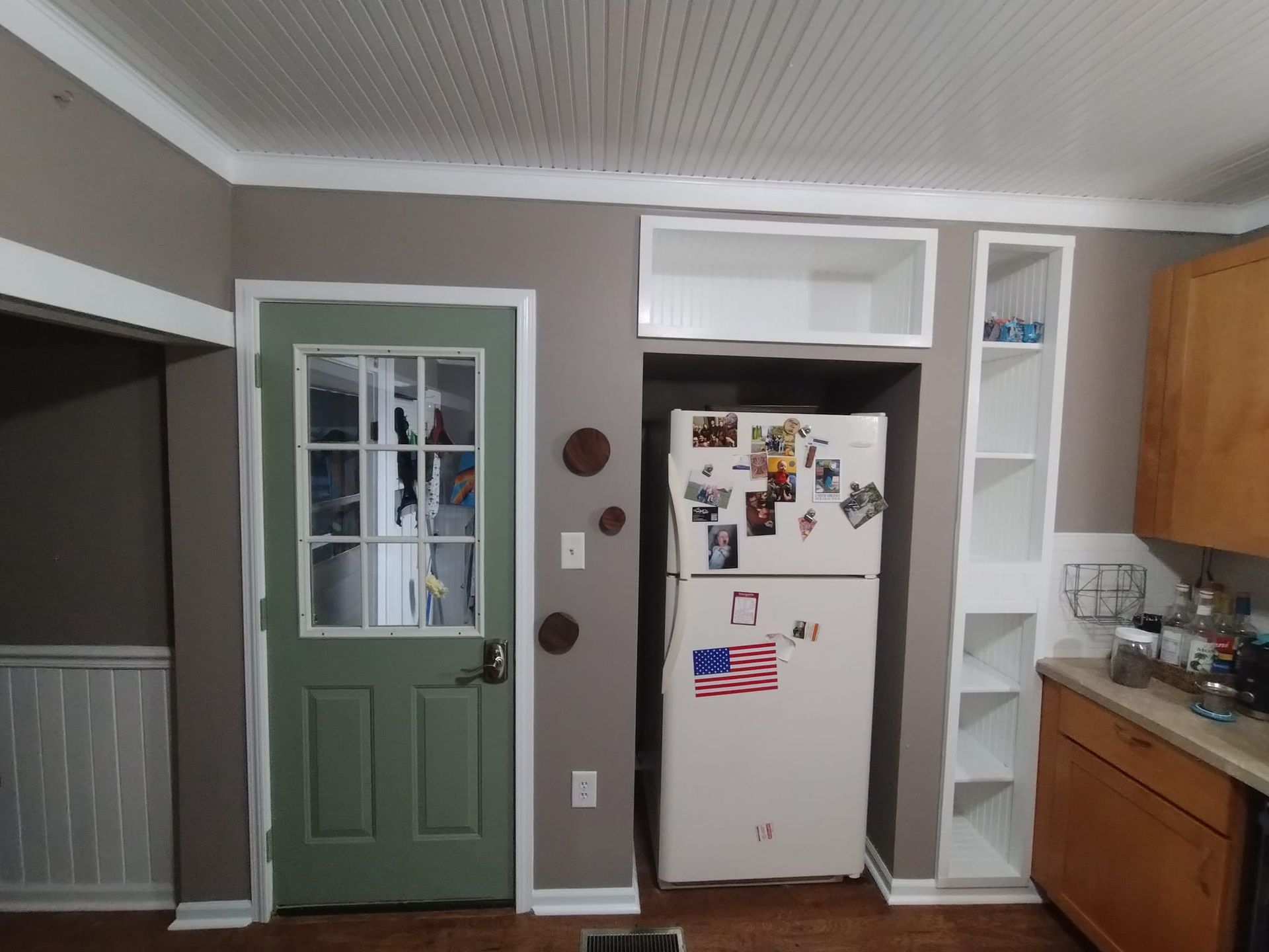 A kitchen with a refrigerator that has an american flag on it
